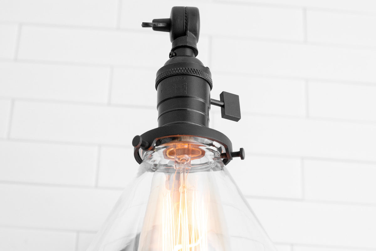 Adjustable industrial wall sconce in antique brass with clear glass shade and visible filament bulb. - SCONCE MODEL NO. 7962