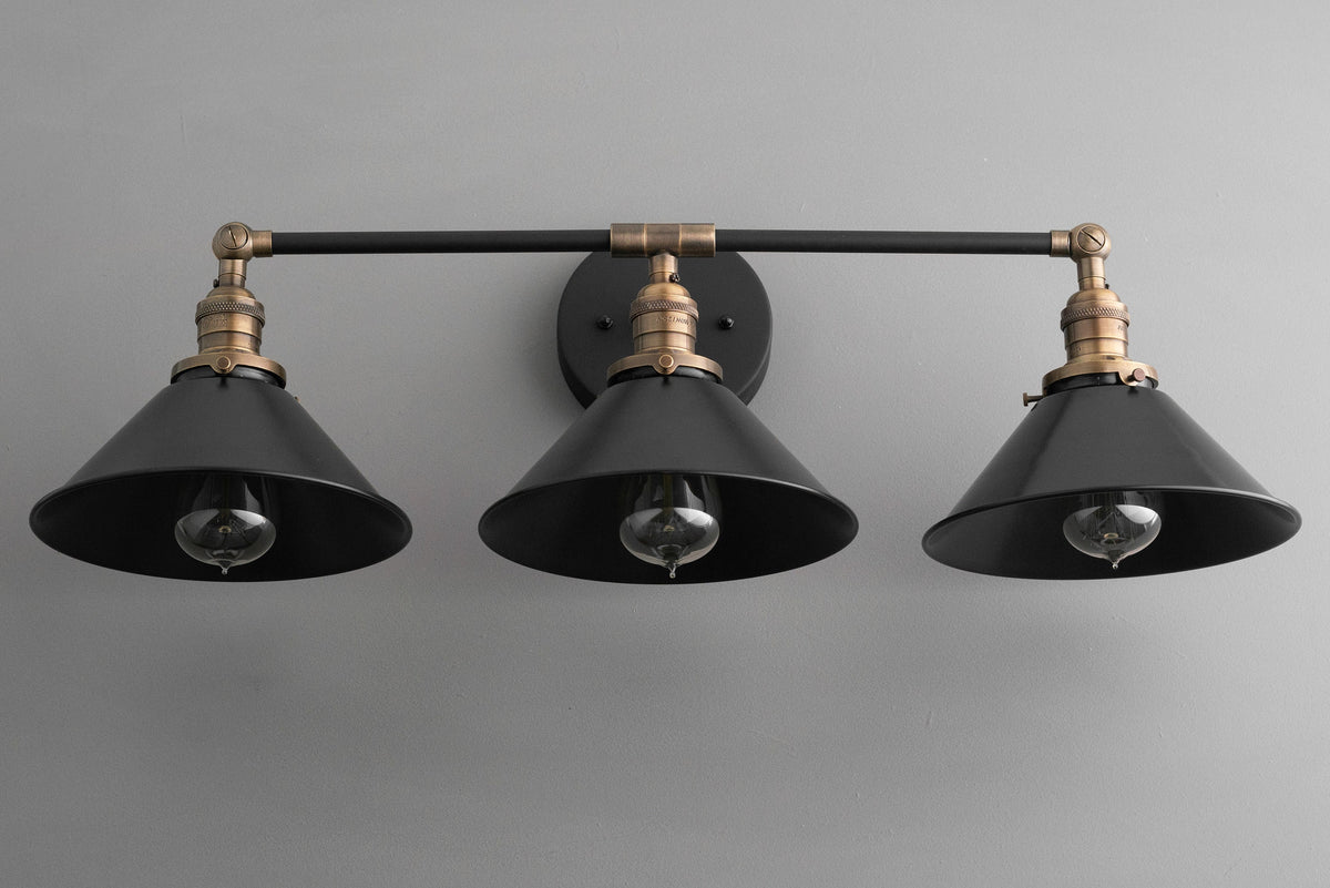 Industrial style black vanity light with three conical metal shades and antique brass accents. - VANITY LIGHT MODEL NO. 3406