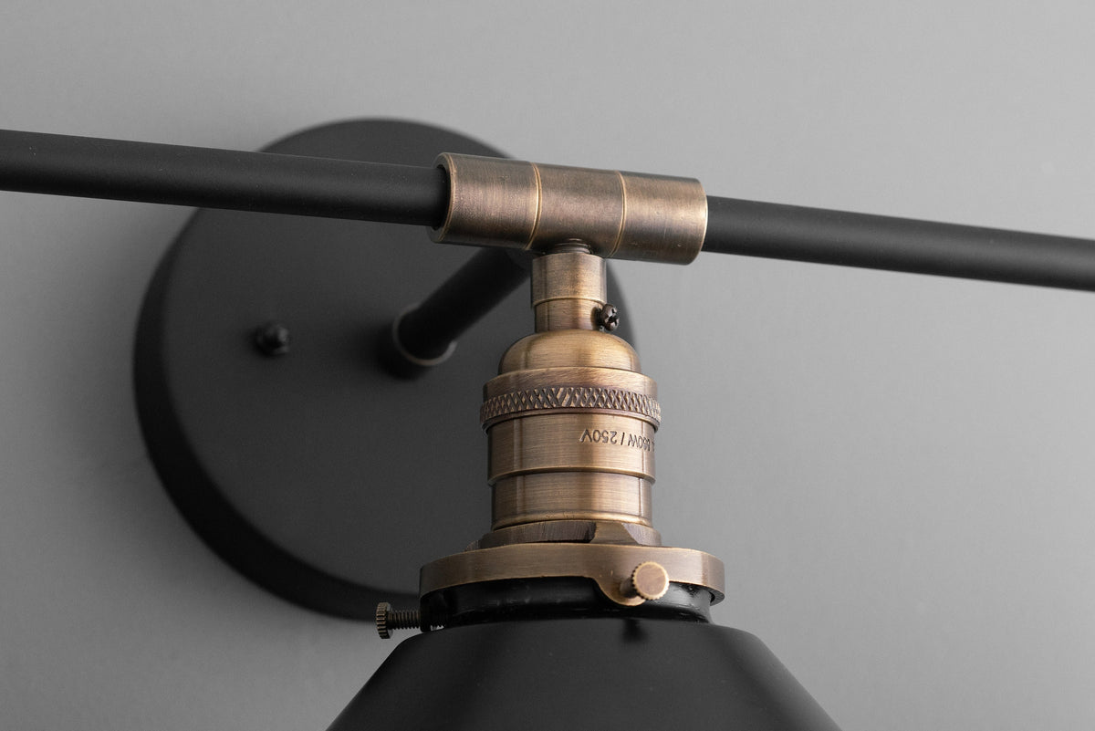 Industrial-style black vanity light fixture with antique brass accents and matte black shade. - VANITY LIGHT MODEL NO. 3406