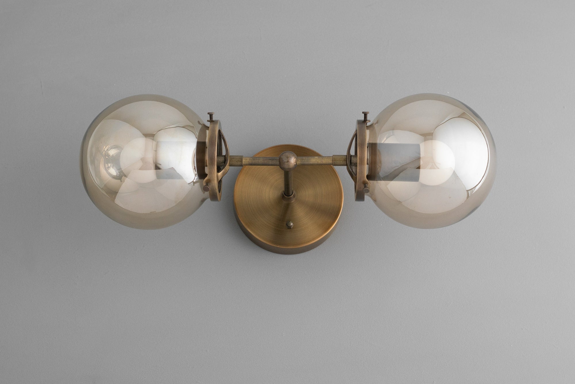 Two-bulb antique brass vanity light with clear globe shades and industrial mid-century design. - VANITY LIGHT MODEL NO. 8983