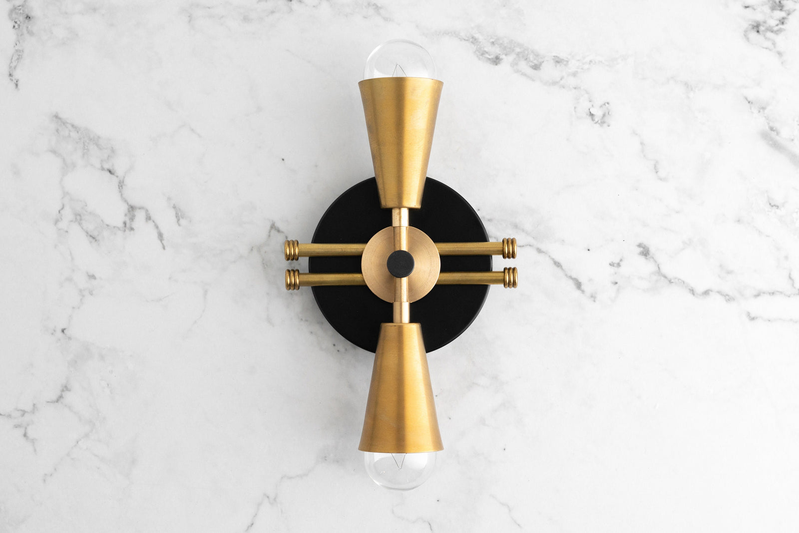 Art Deco black and raw brass up/down wall sconce with exposed bulbs on marble background. - SCONCE MODEL NO. 3419