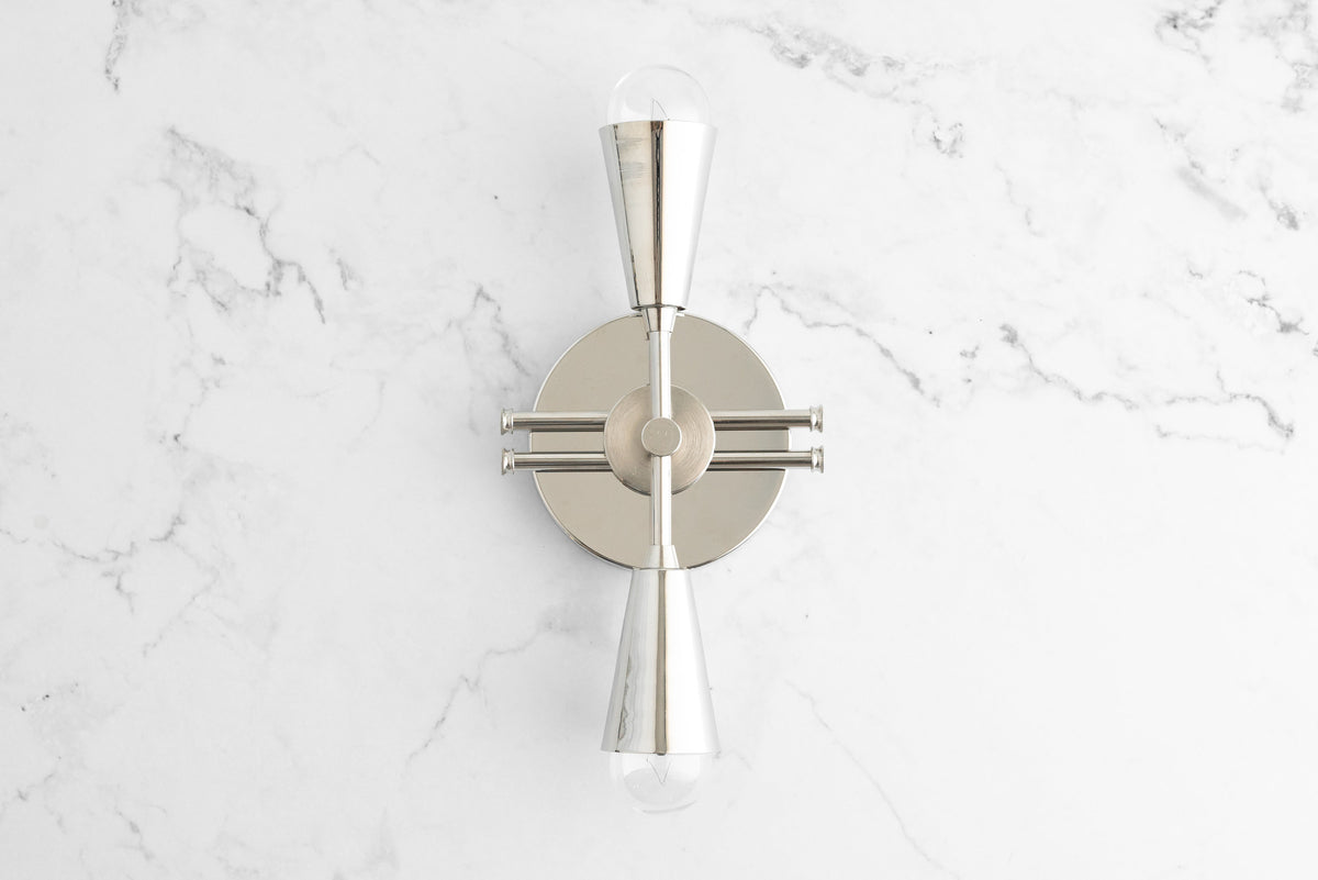 Polished nickel Art Deco sconce with hourglass-shaped bulb holders and round backplate on white marble wall. - SCONCE MODEL NO. 3419