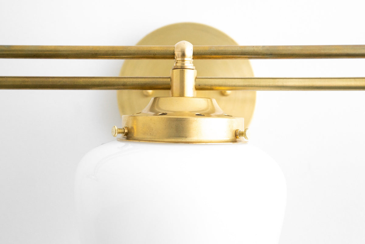 Art Deco vanity light in polished brass with round white glass globe and three-bulb fixture. - VANITY LIGHT MODEL NO. 4352