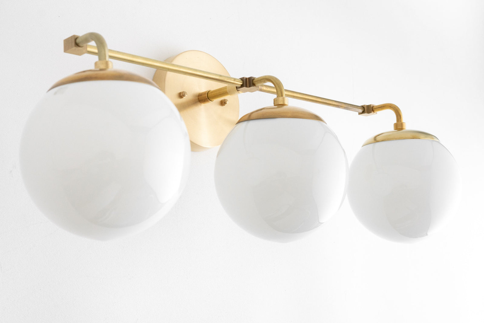 Mid-century modern vanity light with three frosted glass globe shades and raw brass finish. - VANITY LIGHT MODEL NO. 9319