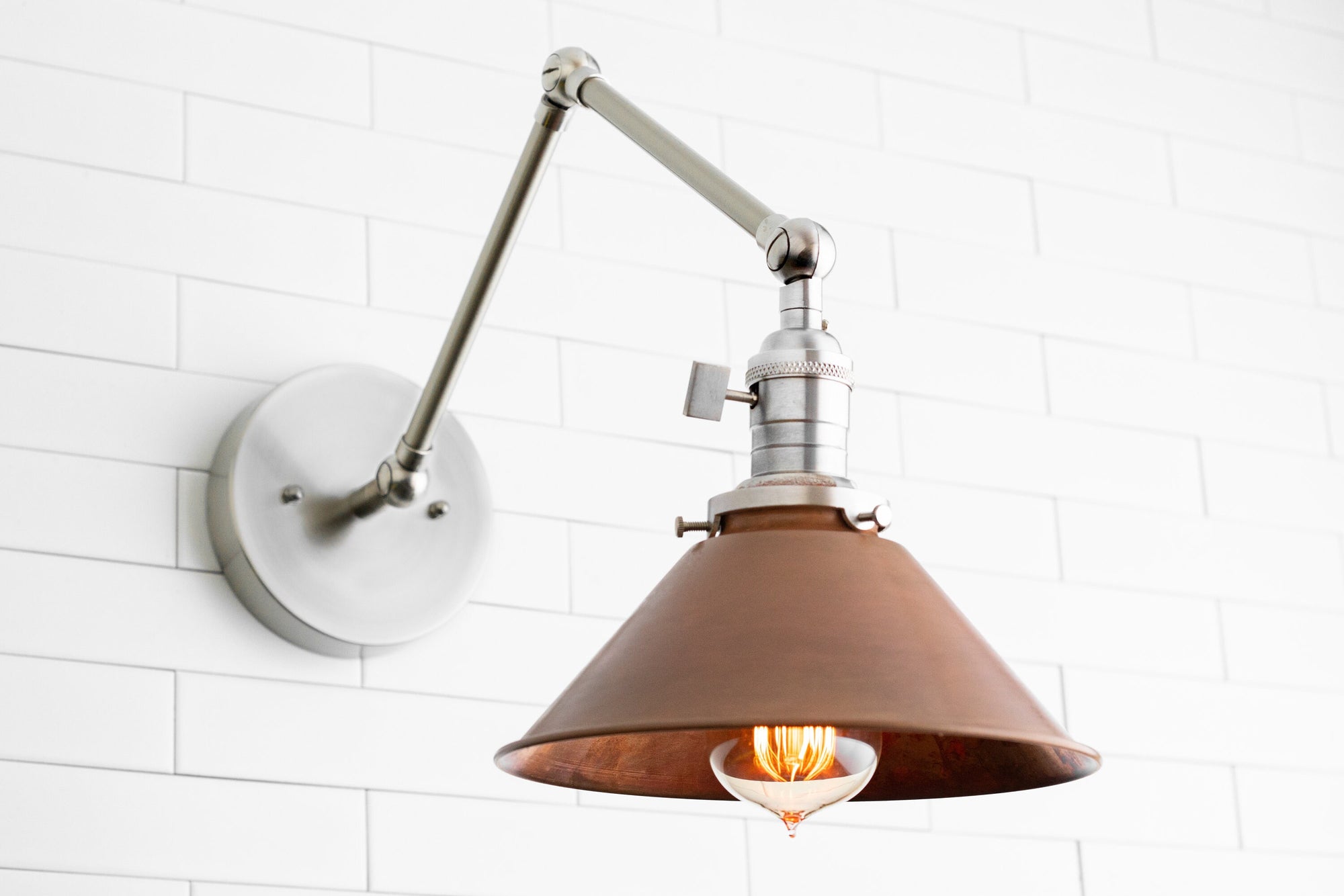 Adjustable wall sconce with polished nickel arm and copper-toned conical shade over exposed filament bulb. - SCONCE MODEL NO. 6668