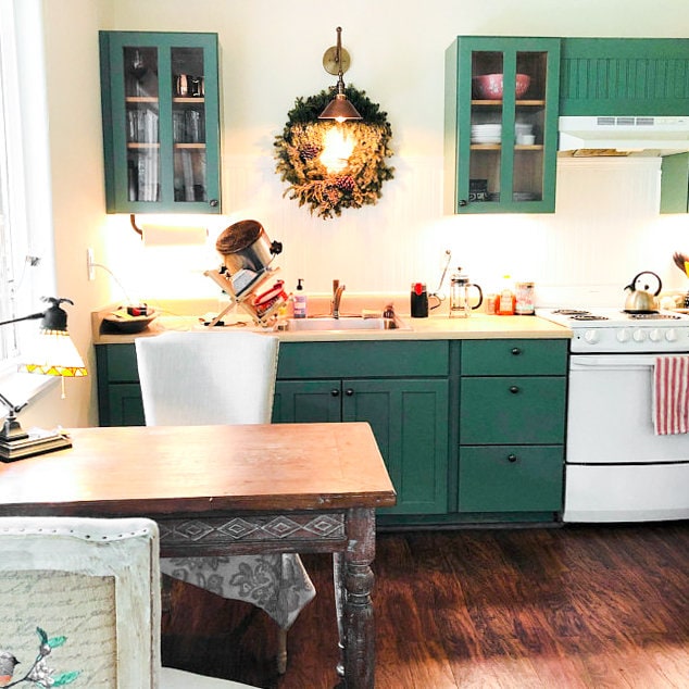 Adjustable raw brass industrial sconce with cone-shaped shade over green kitchen cabinets. - SCONCE MODEL NO. 6668