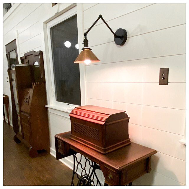 Adjustable industrial wall sconce with black metal arm and conical shade mounted on white shiplap wall. - SCONCE MODEL NO. 6668