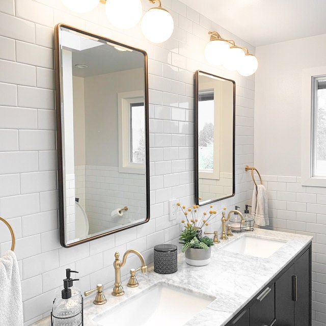Mid-century modern vanity light with three round white glass globes and sealed brass finish above rectangular mirrors. - VANITY LIGHT MODEL NO. 9319