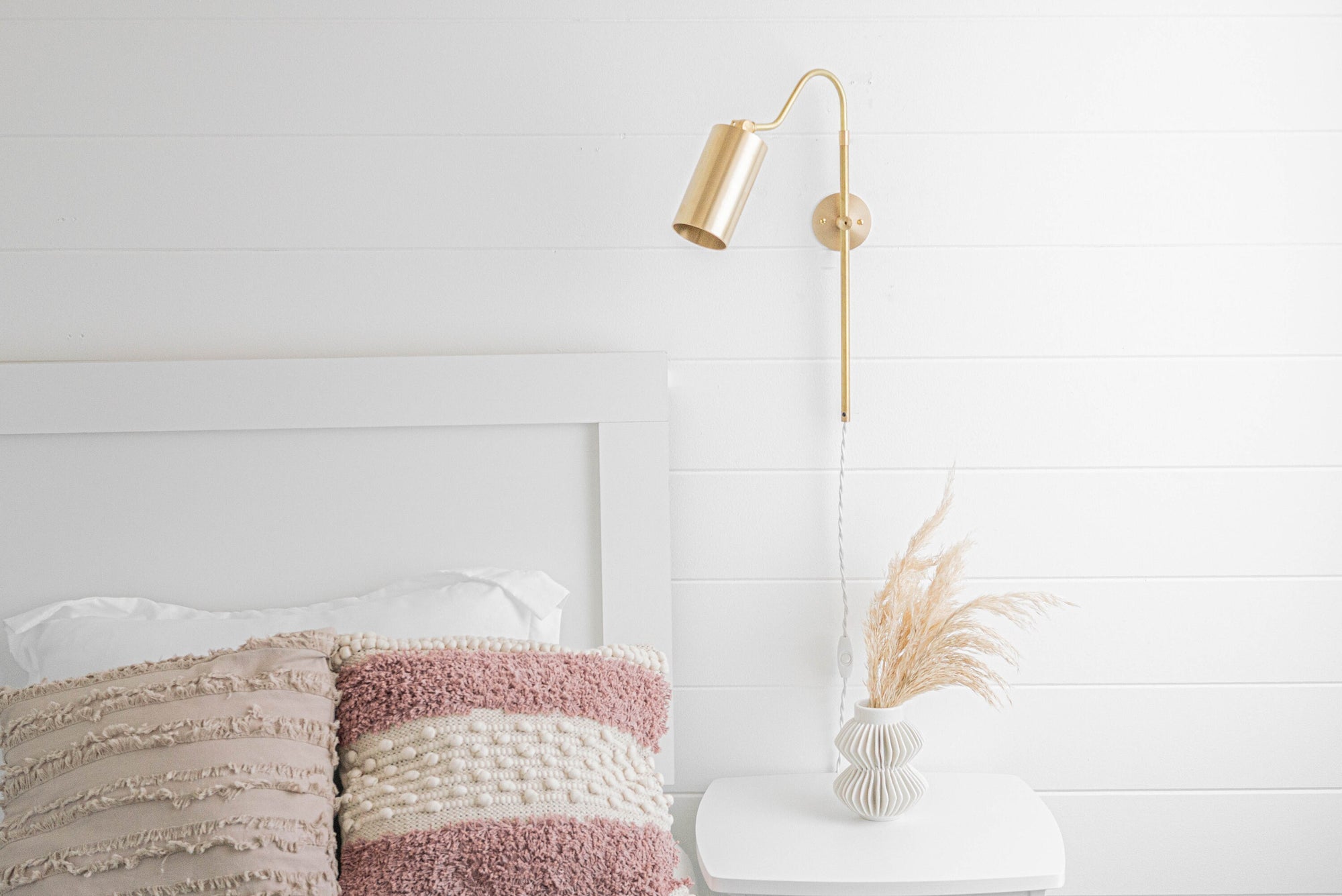 Sealed brass mid century modern adjustable sconce with white cord mounted on white shiplap wall above bedside table and. - SCONCE MODEL NO. 1132