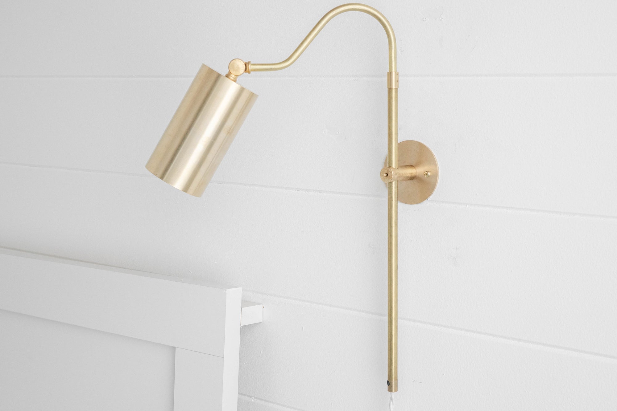 Mid-century modern adjustable brass wall sconce with cylindrical shade and white cord plug-in design. - SCONCE MODEL NO. 1132