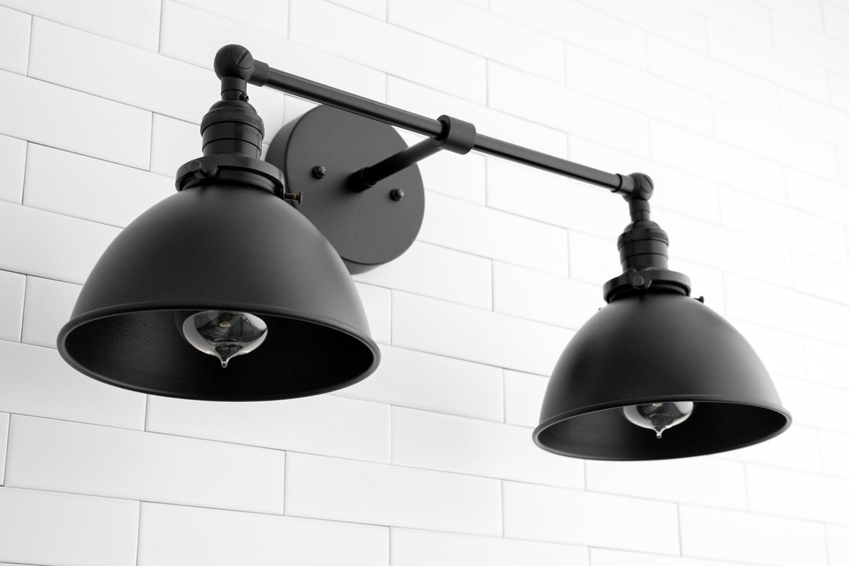 Industrial black metal 2-light adjustable vanity sconce with wide conical shades on white tiled wall. - SCONCE MODEL NO. 8791