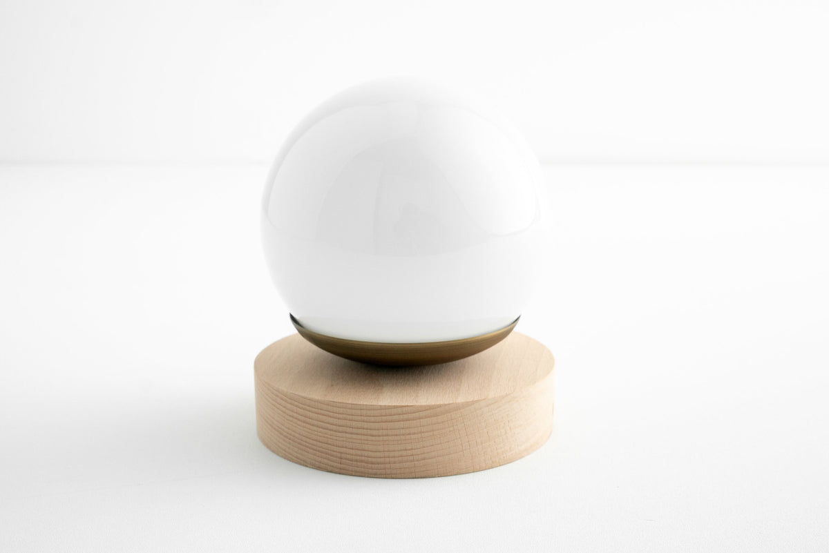 Scandinavian-style sconce with white globe shade on natural oak wood base and antique brass accent. - SCONCE MODEL NO. 5719