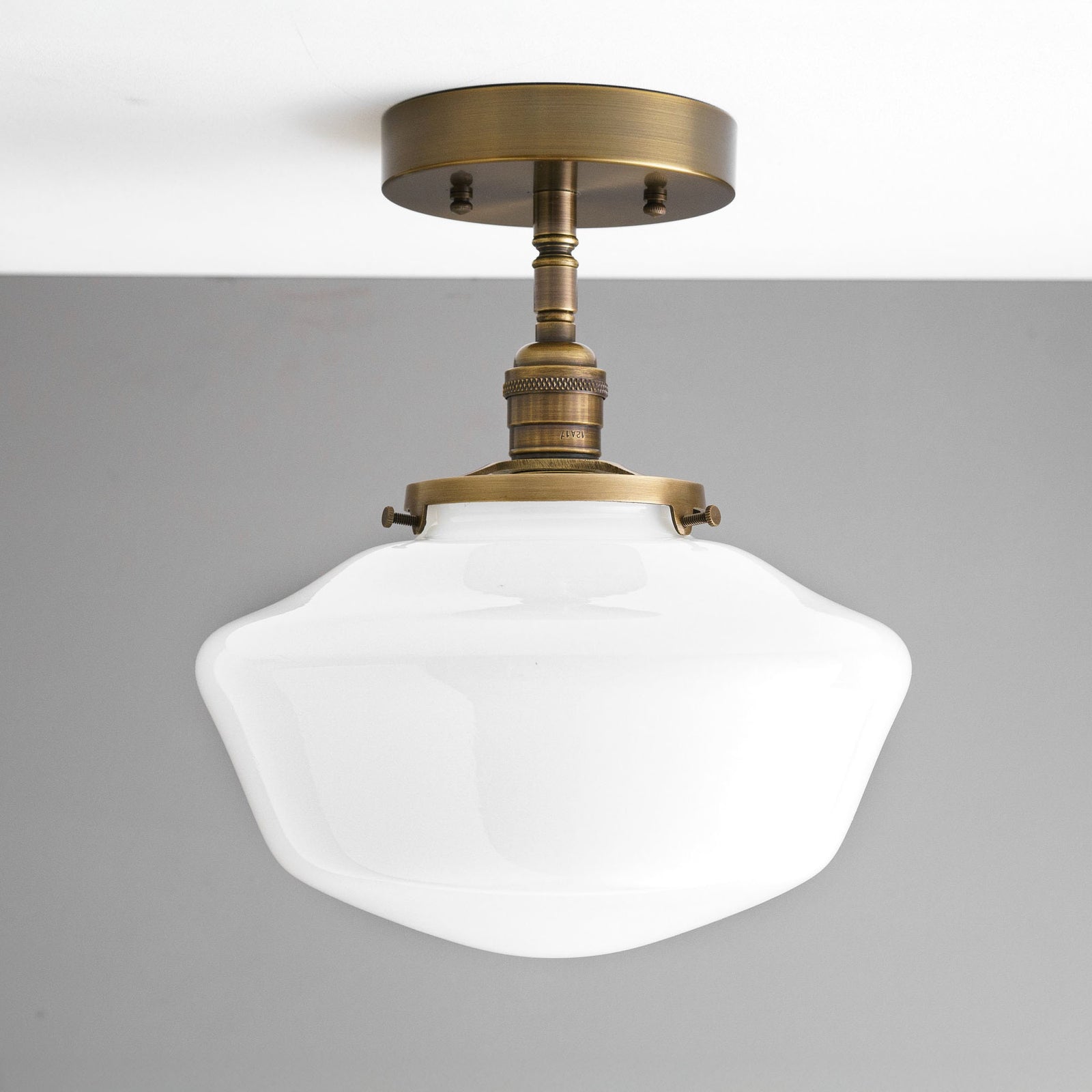 Semi-flush ceiling light with an antique brass finish and a white curvy glass globe shade. - CEILING LIGHT MODEL NO. 9512