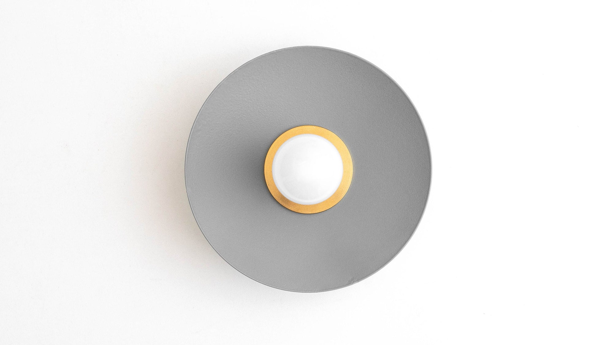 Raw brass sconce with a flush gray metal shade and exposed round bulb center. - SCONCE MODEL NO. 9660