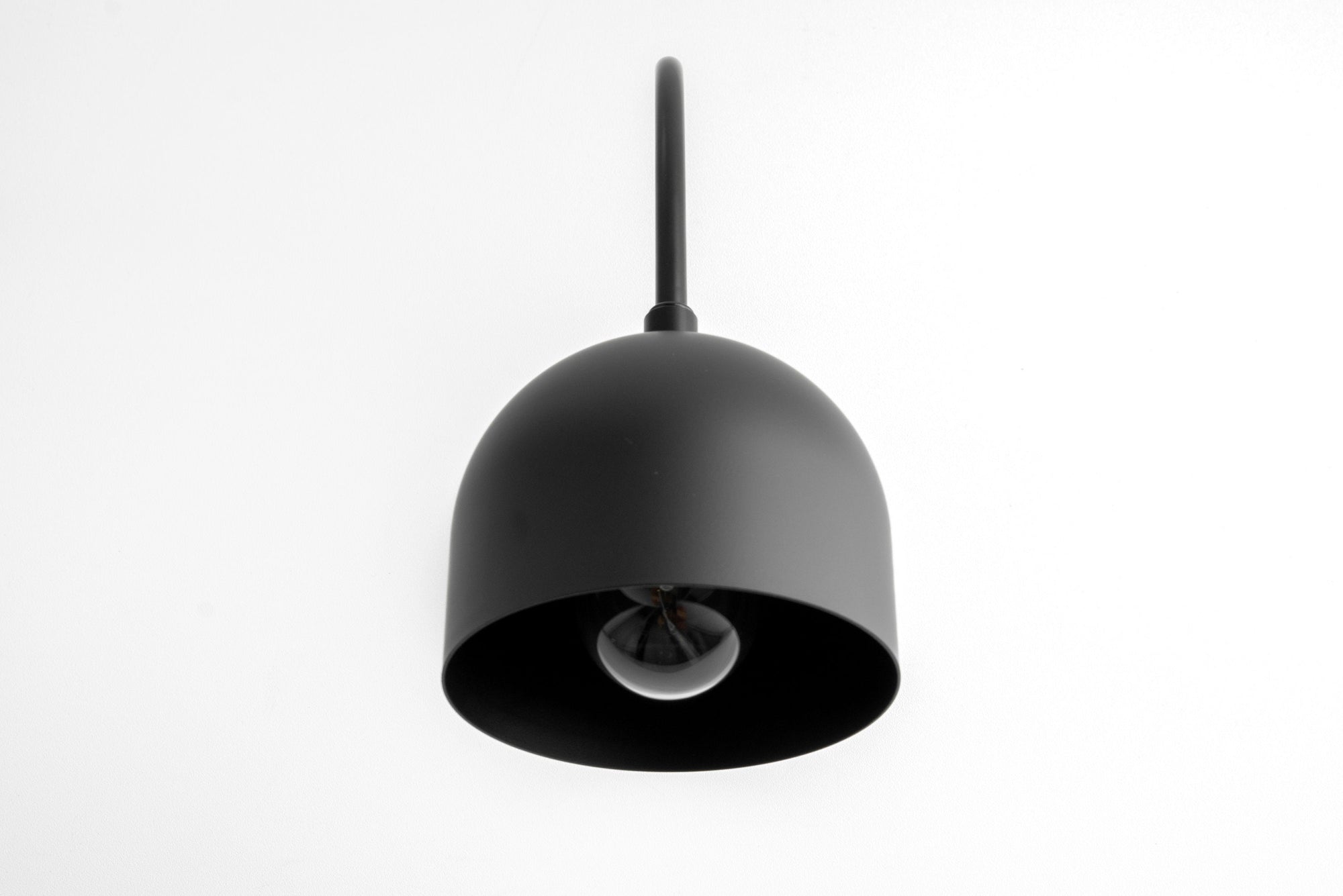 Matte black semi-flush mount sconce with dome-shaped shade and exposed bulb. - SCONCE MODEL NO. 8586