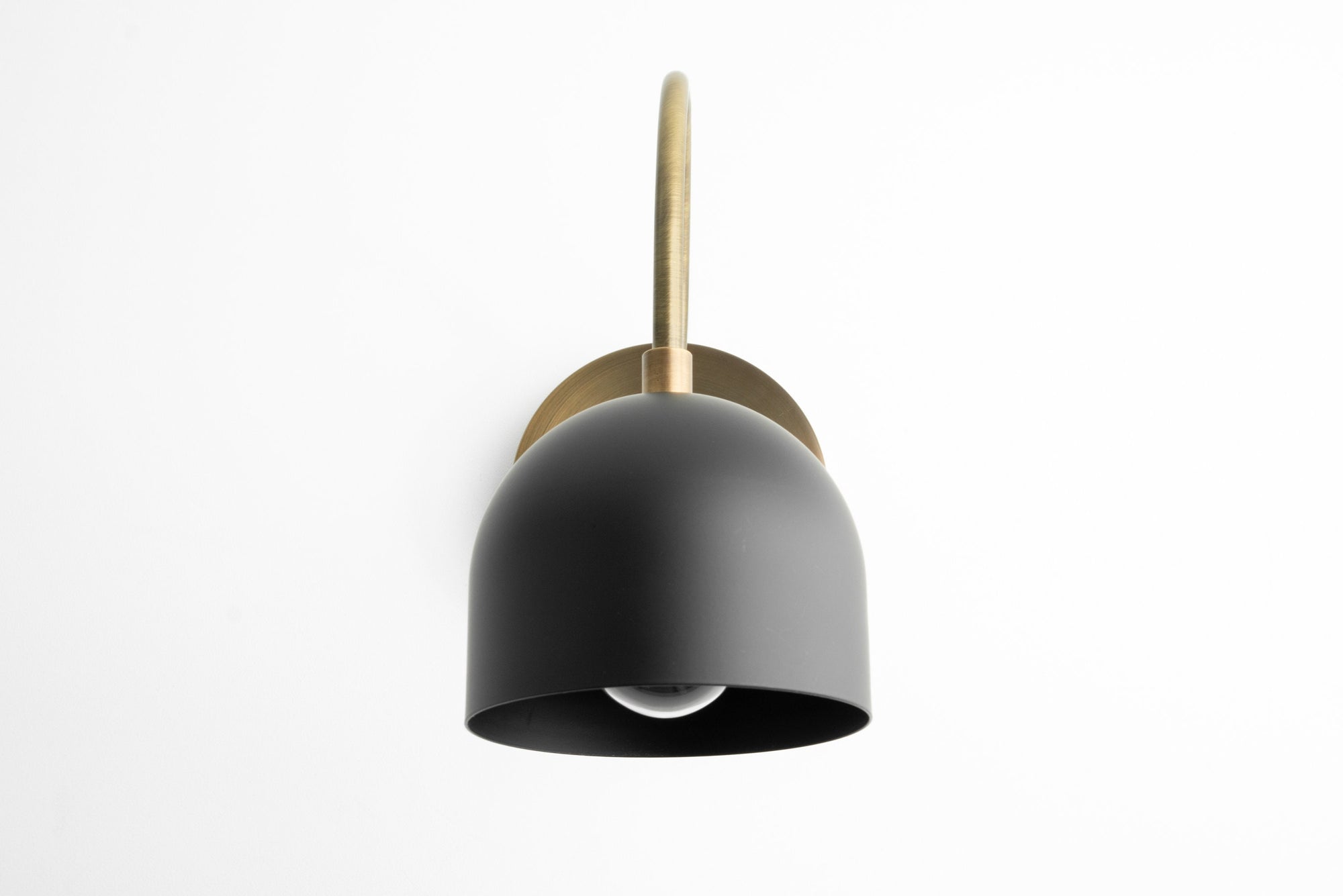 Mid-century modern matte black bell-shaped metal sconce with brass arm and round backplate. - SCONCE MODEL NO. 8586