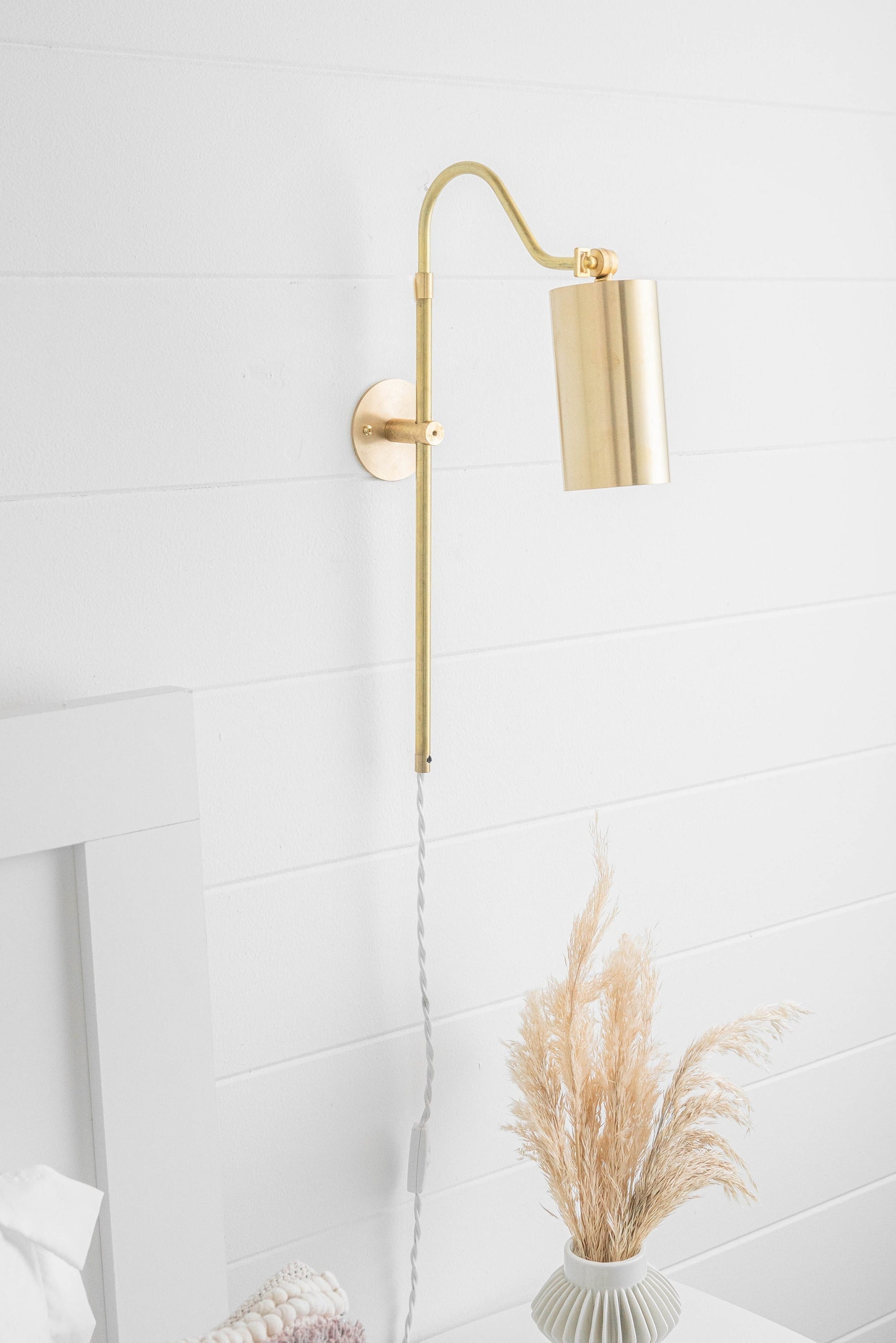 Mid-century modern adjustable brass wall sconce with cylindrical shade and white cord. - SCONCE MODEL NO. 1132