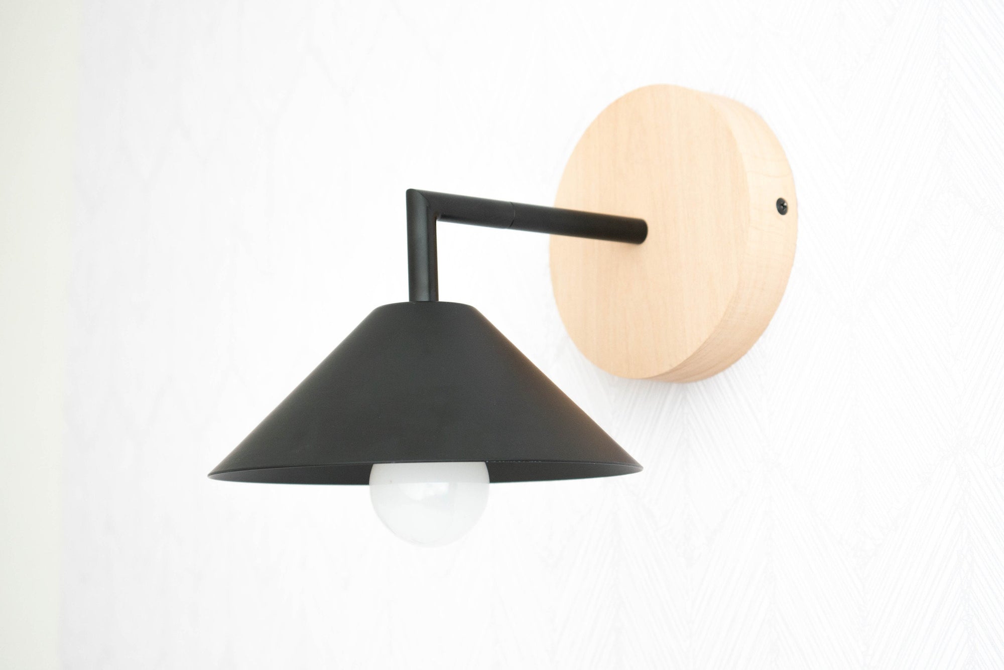 Black metal cone shade sconce with natural beechwood round wall mount and visible bulb. - SCONCE MODEL NO. 1721