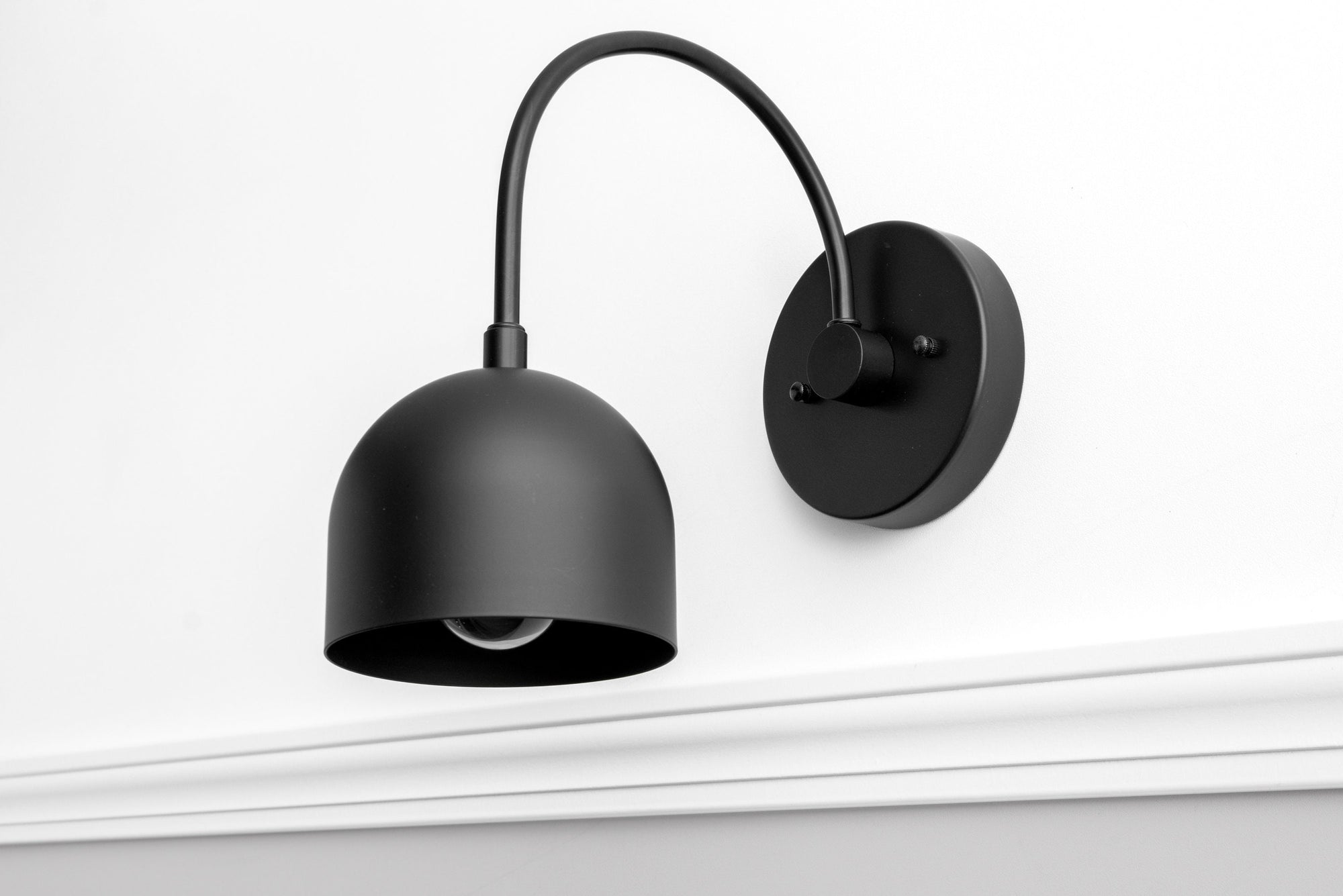 Matte black mid-century modern wall sconce with dome-shaped shade and curved arm. - SCONCE MODEL NO. 8586