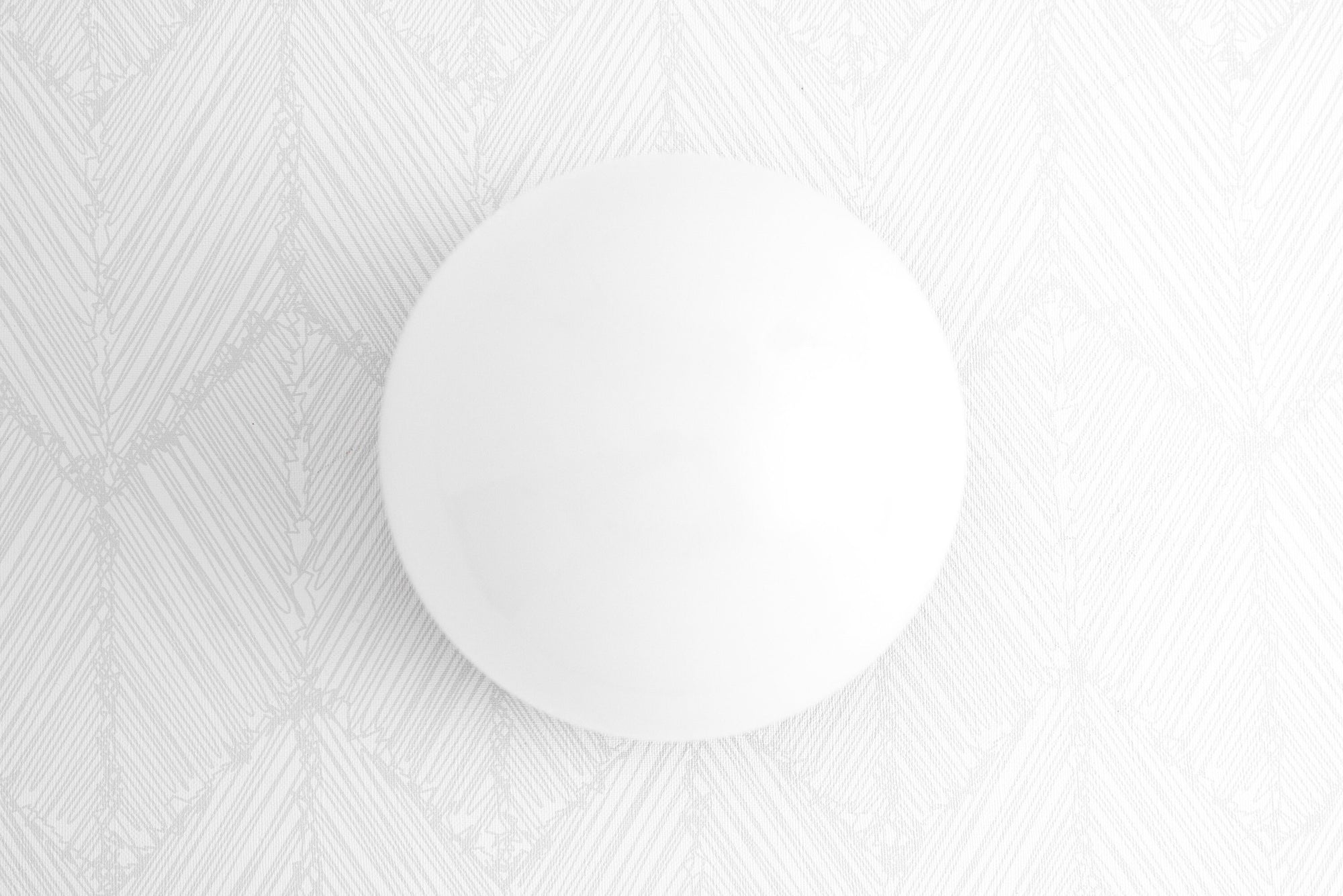 White globe wall sconce with natural wood base on textured white wall. - SCONCE MODEL NO. 5719