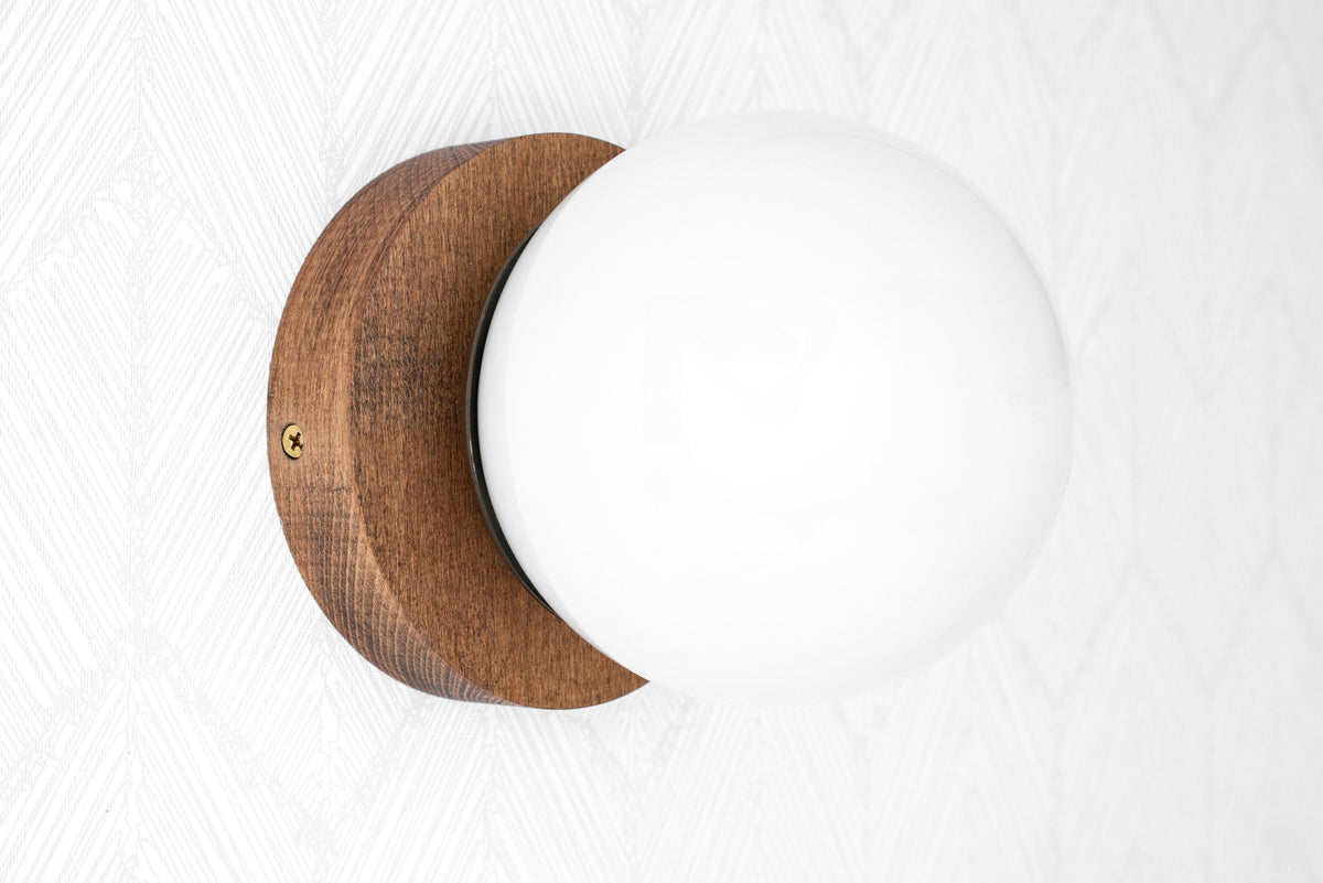 Wall-mounted sconce with round white glass globe and natural wood base in warm brown finish. - SCONCE MODEL NO. 5719