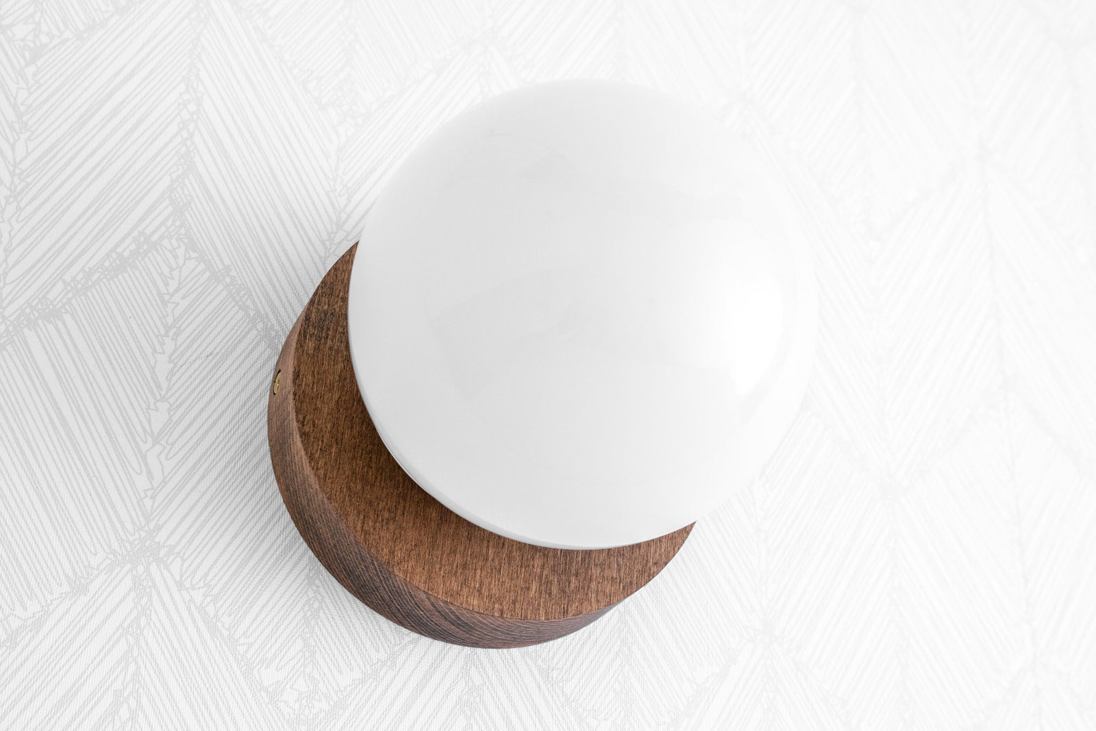 Scandinavian sconce with round white glass globe and natural wood base flush mounted on white textured wall. - SCONCE MODEL NO. 5719