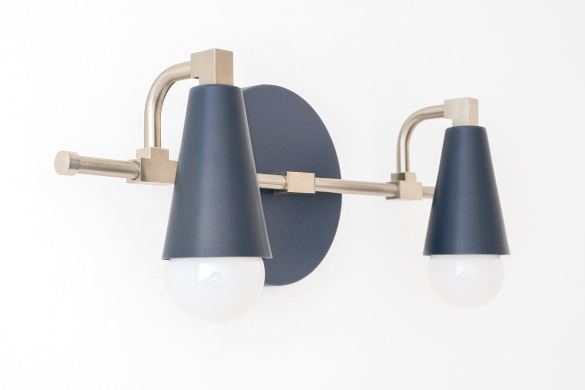 Scandinavian style vanity light with two exposed bulbs, brushed nickel frame, and coal blue cone shades. - VANITY LIGHT MODEL NO. 1229
