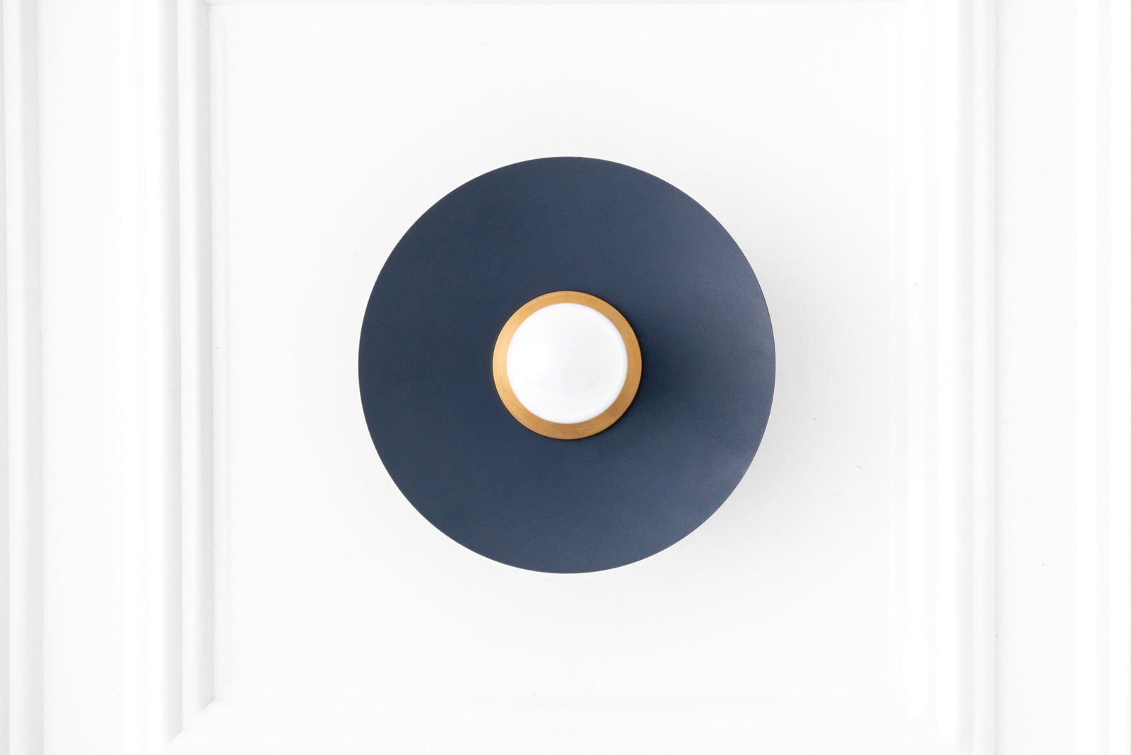 Raw brass sconce with coal blue circular backplate and exposed bulb mounting. - SCONCE MODEL NO. 9660