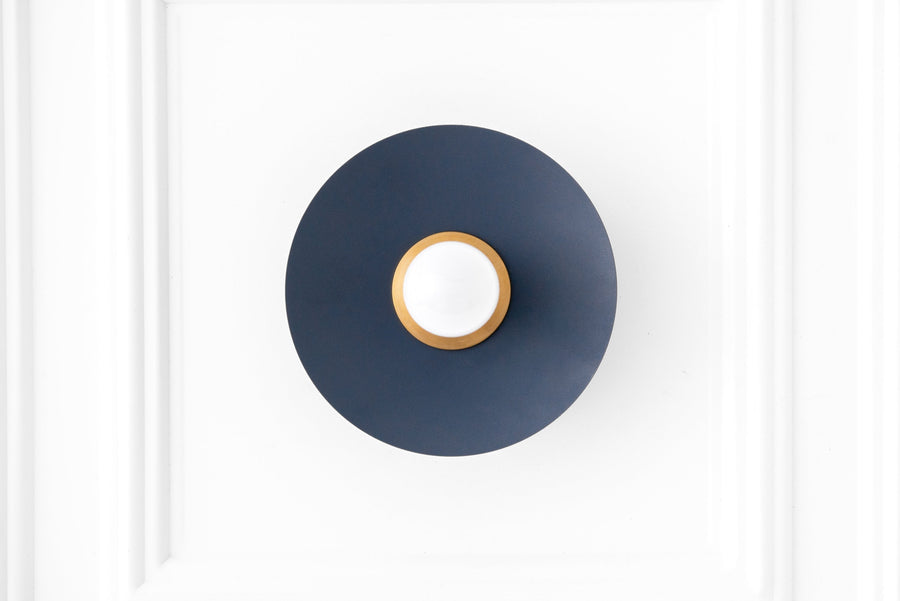 Raw brass sconce with coal blue circular backplate and exposed bulb mounting. - SCONCE MODEL NO. 9660