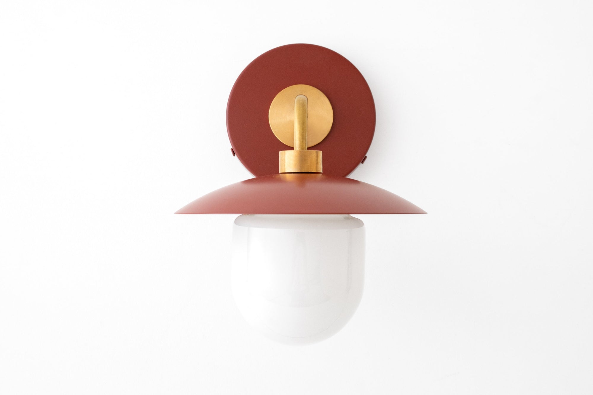 Mid-century modern wall sconce with raw brass fixture and brick red metal backplate and shade, white globe diffuser. - SCONCE MODEL NO. 7039