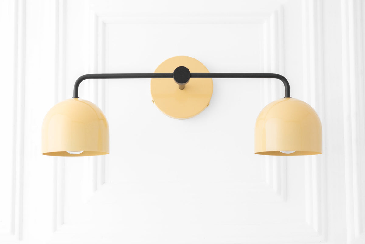 Mid-century modern two-bulb vanity light with black frame and yellow dome shades. - VANITY LIGHT MODEL NO. 2082
