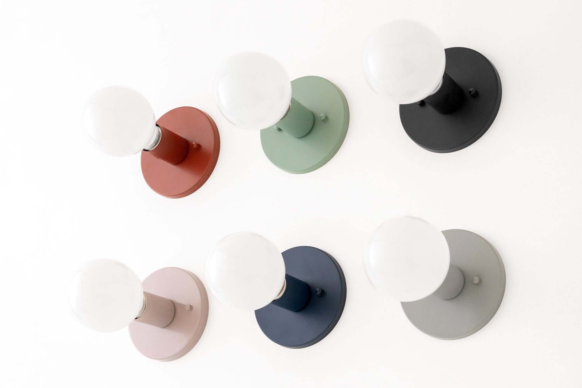 Six flush-mounted wall sconces with white globe bulbs in mauve, green, black, cream, coal blue, and gray matte finishes. - SCONCE MODEL NO. 4460