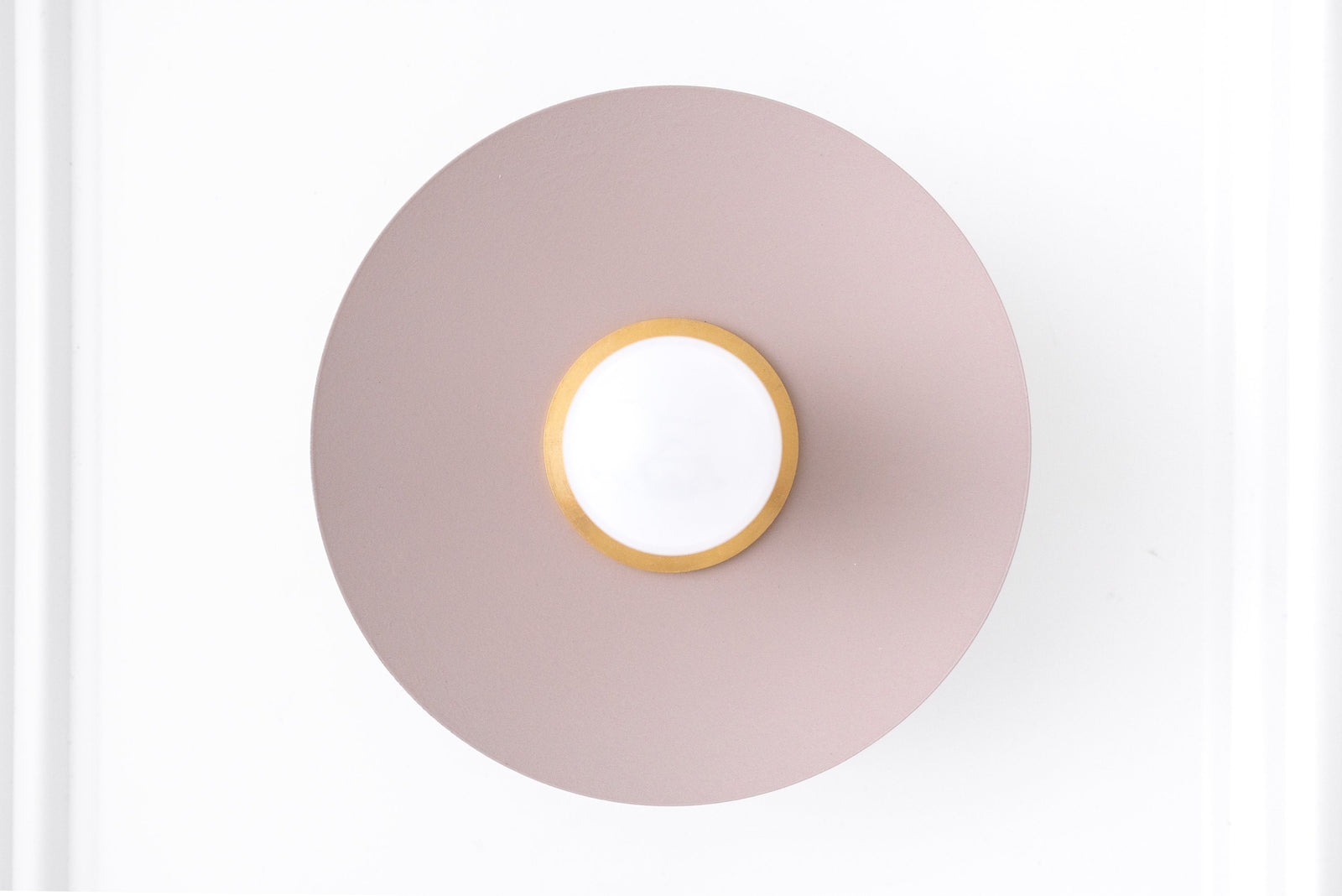 Scandinavian style wall sconce with raw brass center and mauve circular backplate. - SCONCE MODEL NO. 9660
