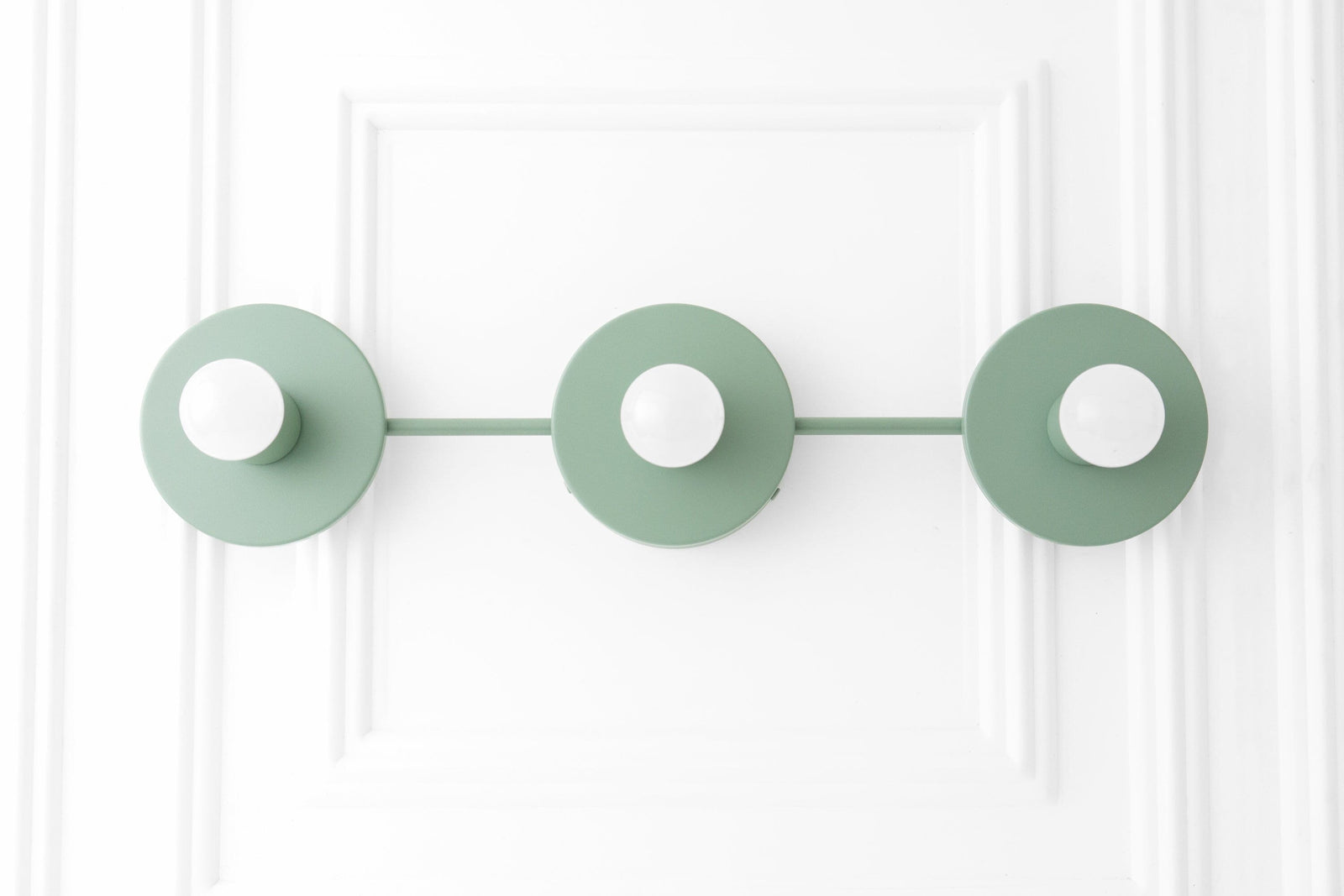 Scandinavian style vanity light with three matte green circular shades and exposed bulbs on a horizontal bar. - VANITY LIGHT MODEL NO. 5708