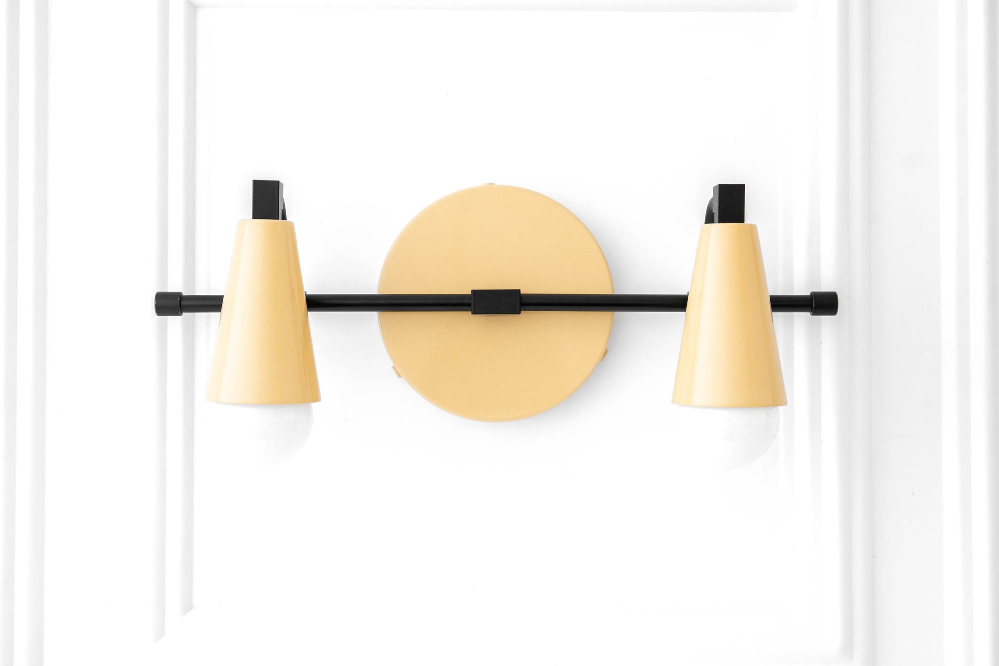 Black and mauve industrial vanity light with two bare cone-shaped bulbs mounted on a horizontal bar. - VANITY LIGHT MODEL NO. 1229