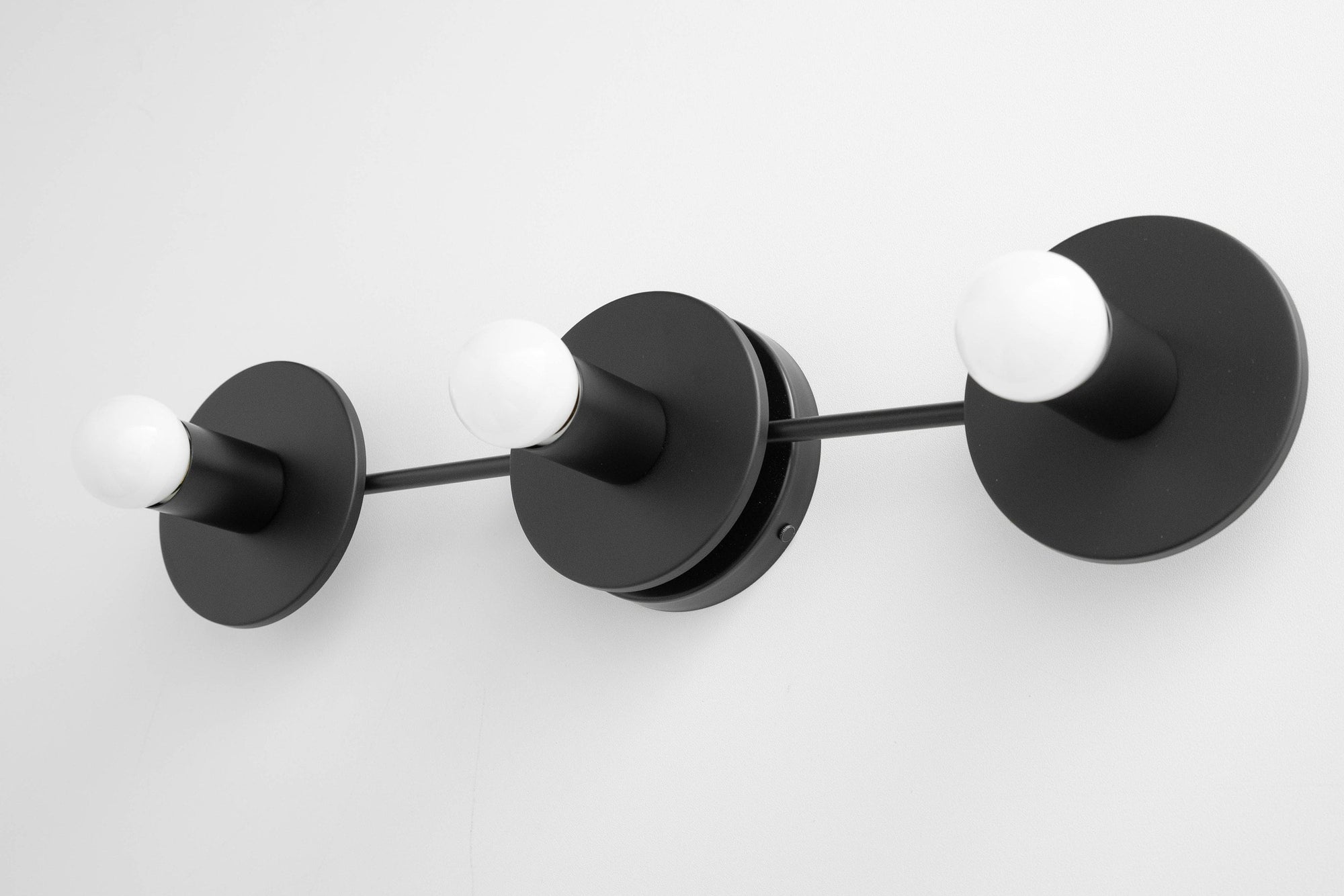 Black modern vanity light with three exposed round bulbs and matte finish. - VANITY LIGHT MODEL NO. 5708