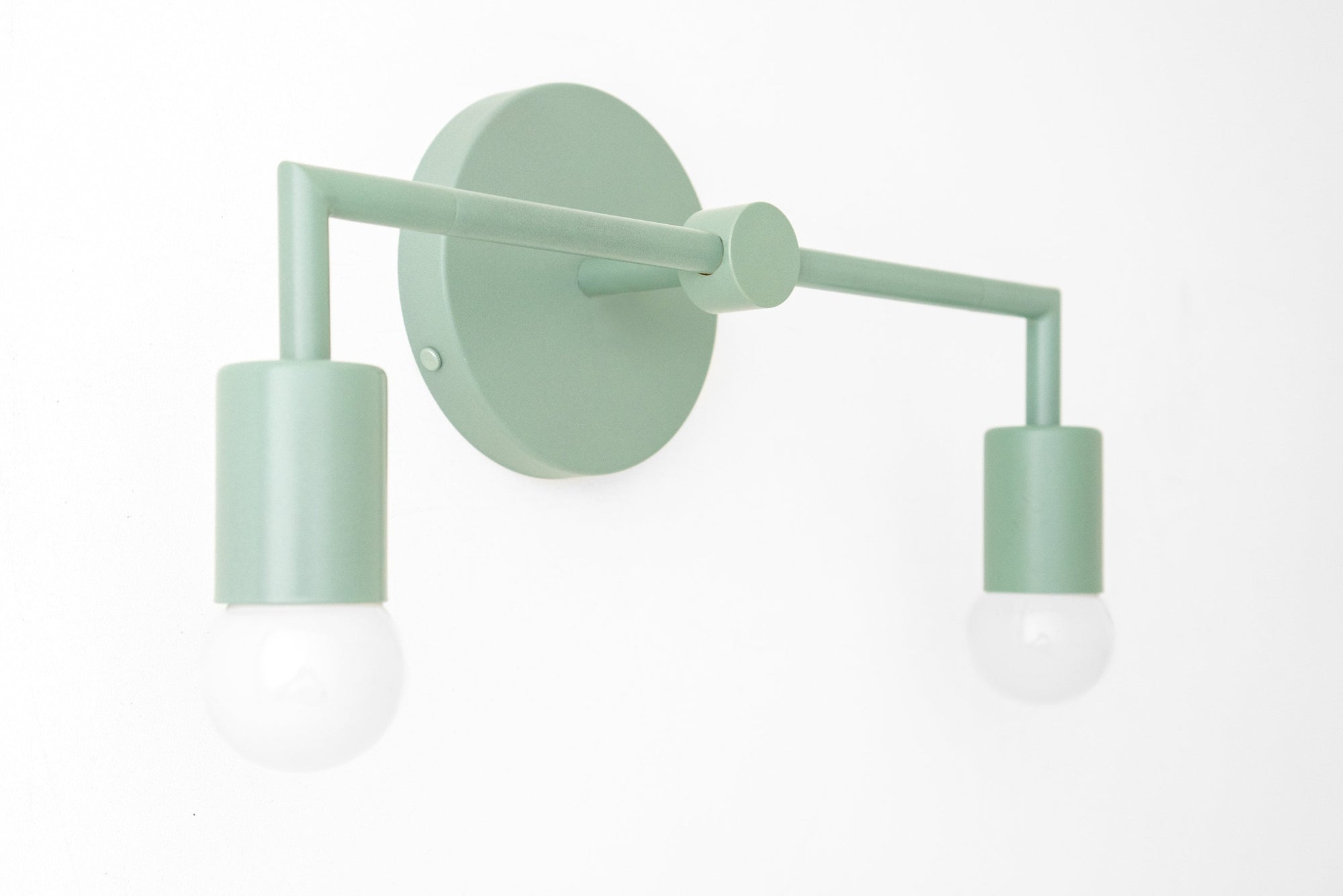 Scandinavian-style mint green metal vanity light with two exposed bulbs and round wall mount. - VANITY LIGHT MODEL NO. 1561