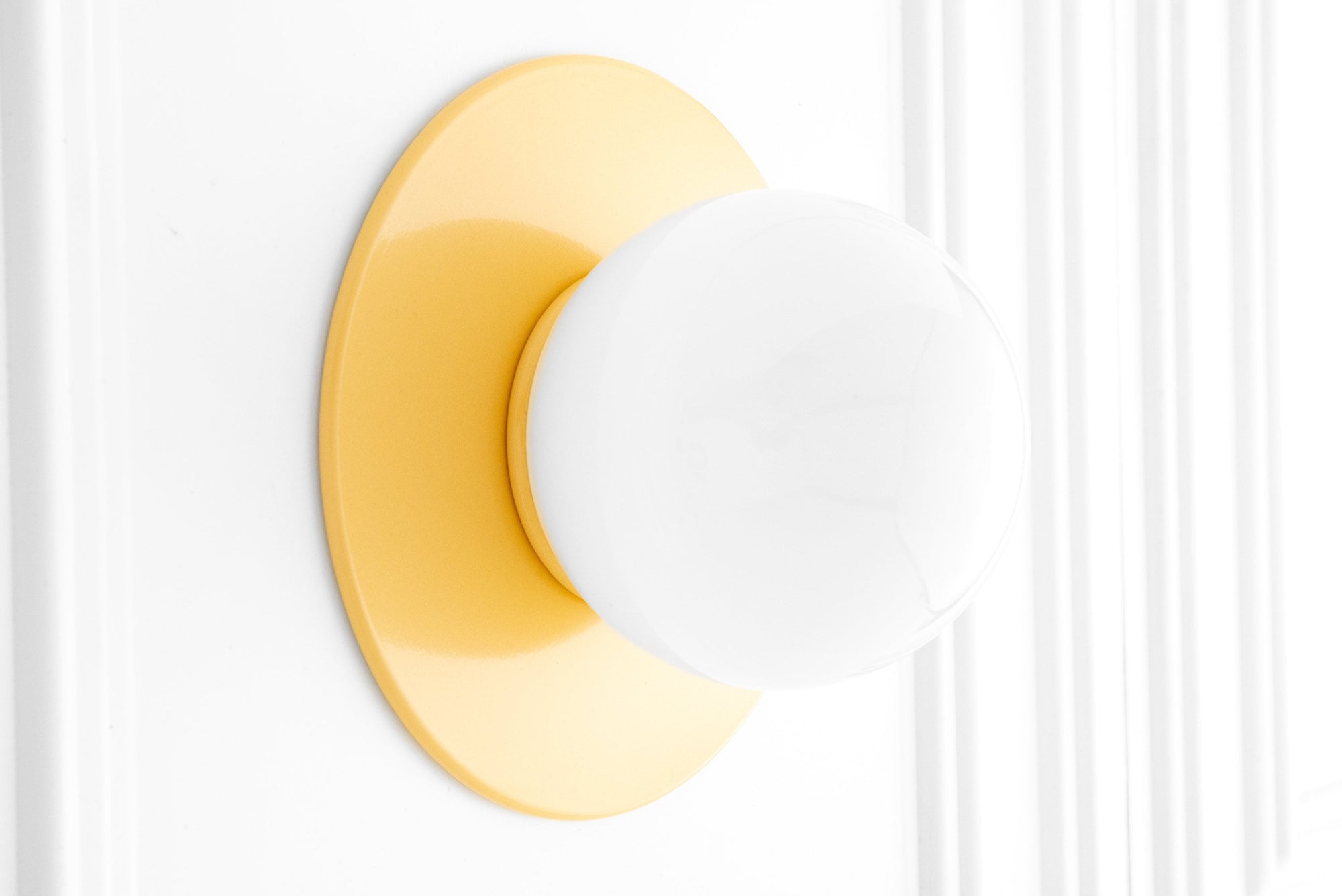 Yellow Scandinavian-style sconce with round white globe and flush mount base. - SCONCE MODEL NO. 2277