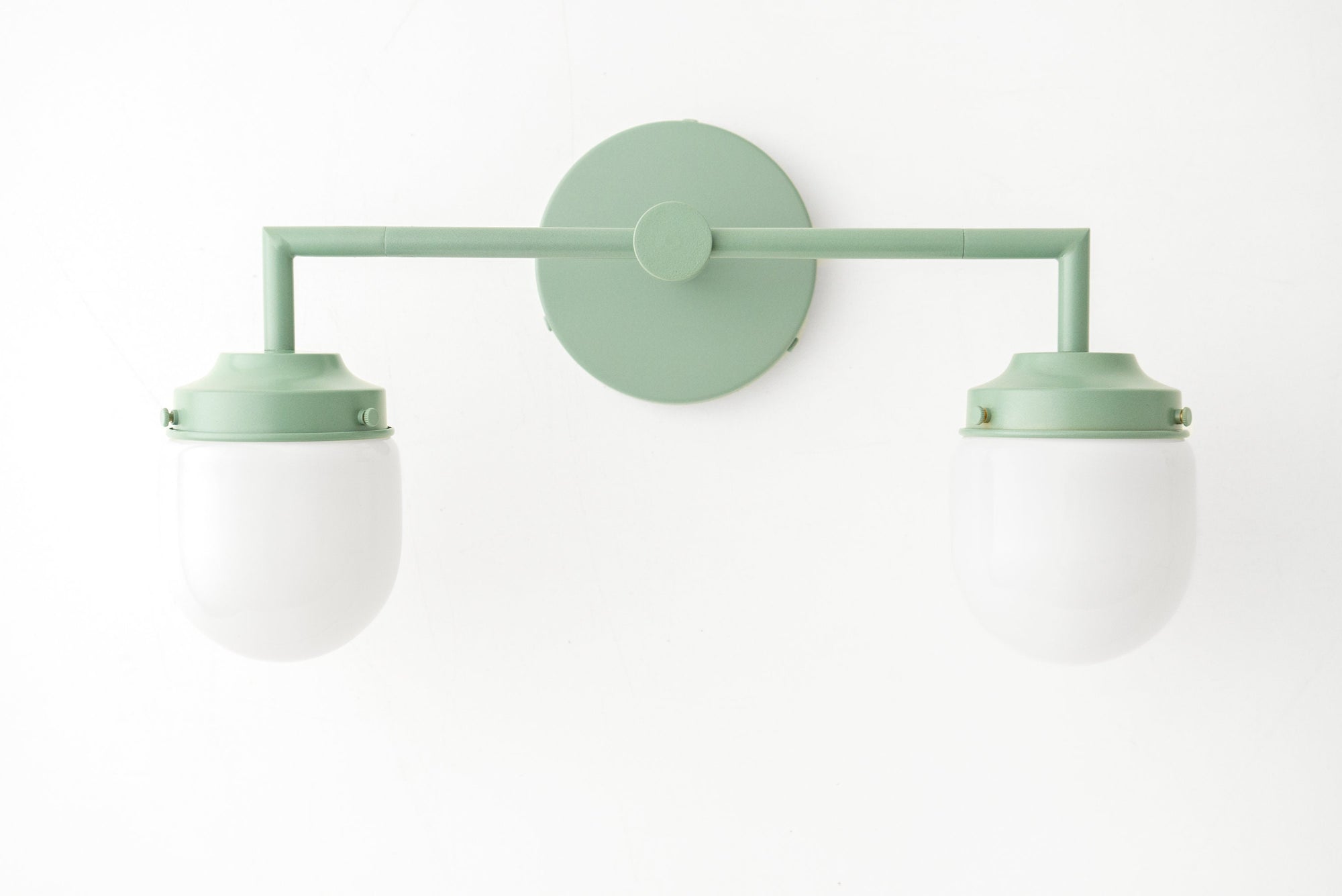 Art Deco style green metal vanity light with two white globe bulbs and circular wall mount. - VANITY LIGHT MODEL NO. 7536