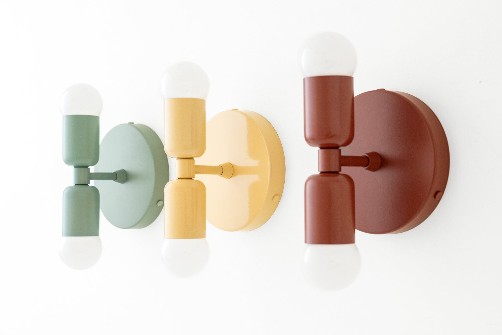 Three mid-century modern double-ended sconces in green, yellow, and brick red with white bulbs. - SCONCE MODEL NO. 2660