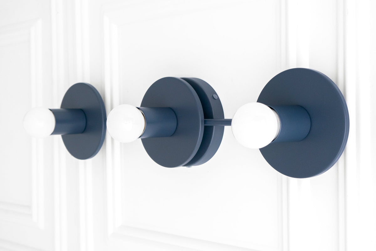 Matte coal blue three-bulb vanity light with exposed round white bulbs and circular backplates. - VANITY LIGHT MODEL NO. 5708