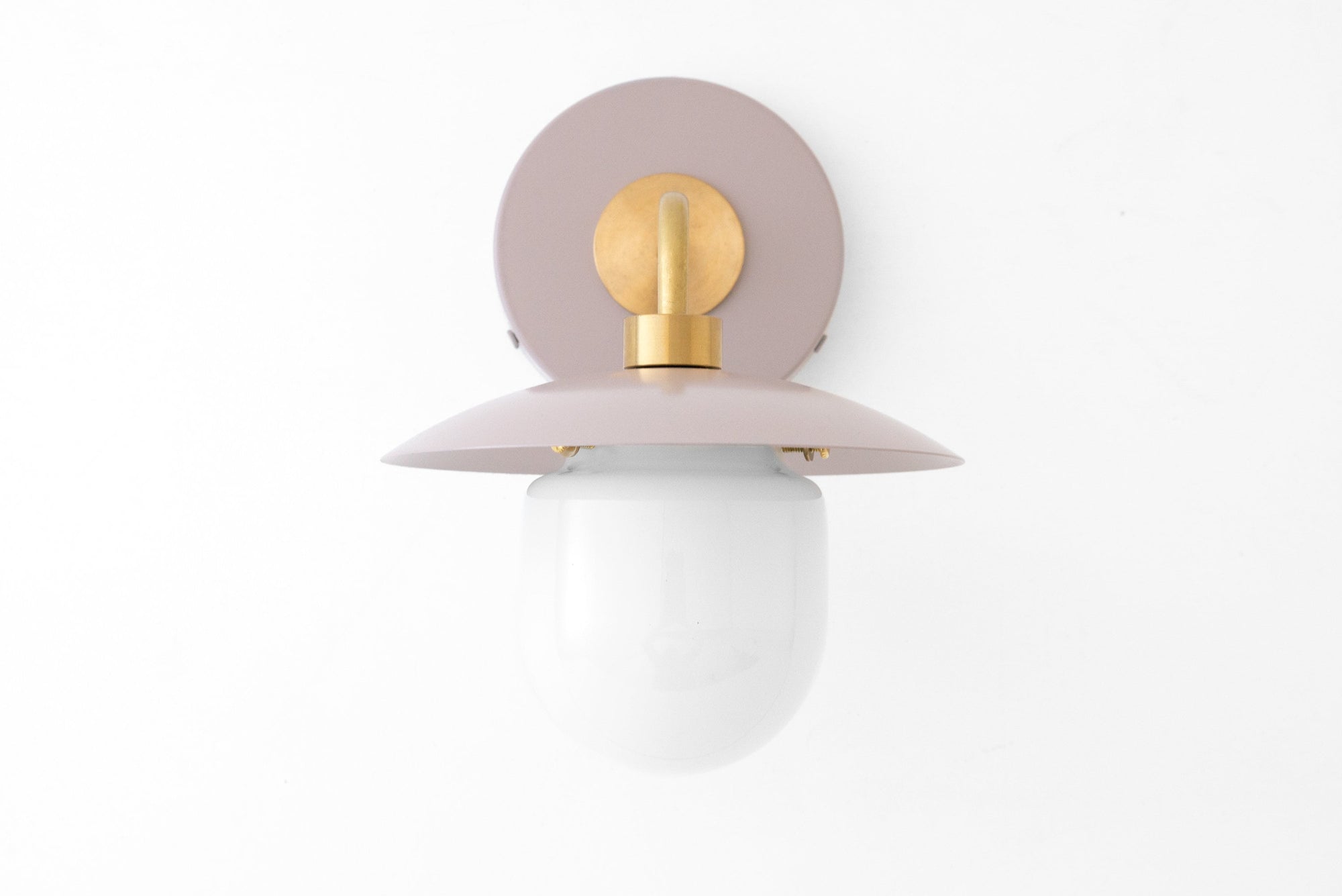 Mid-century modern wall sconce with raw brass fixture and mauve metal backplate and shade, white globe shade. - SCONCE MODEL NO. 7039