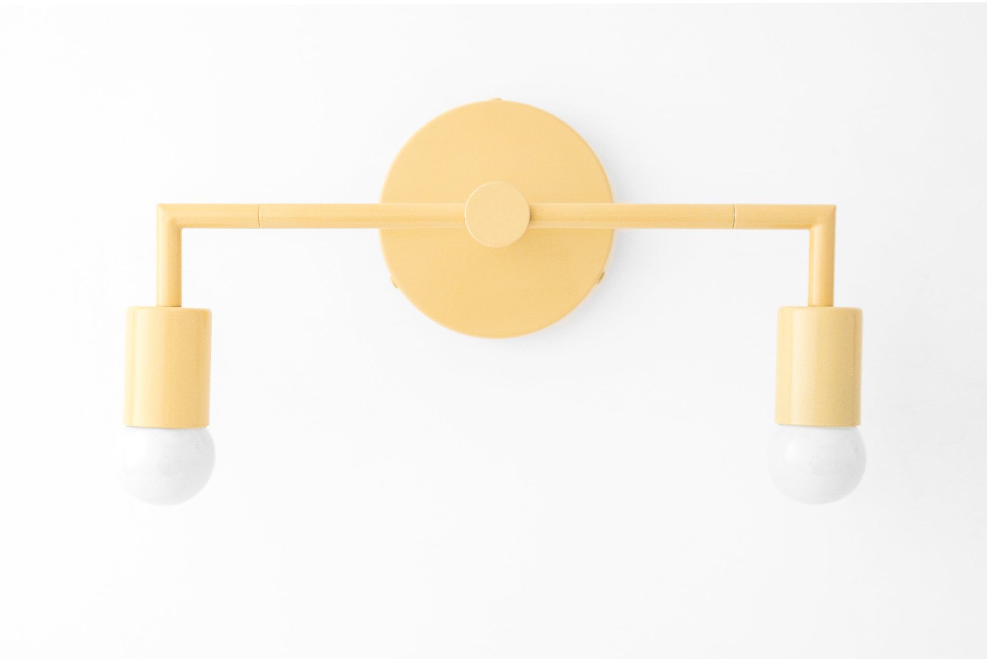 Mid-century modern yellow metal vanity light with two bare bulbs and round wall mount. - VANITY LIGHT MODEL NO. 1561