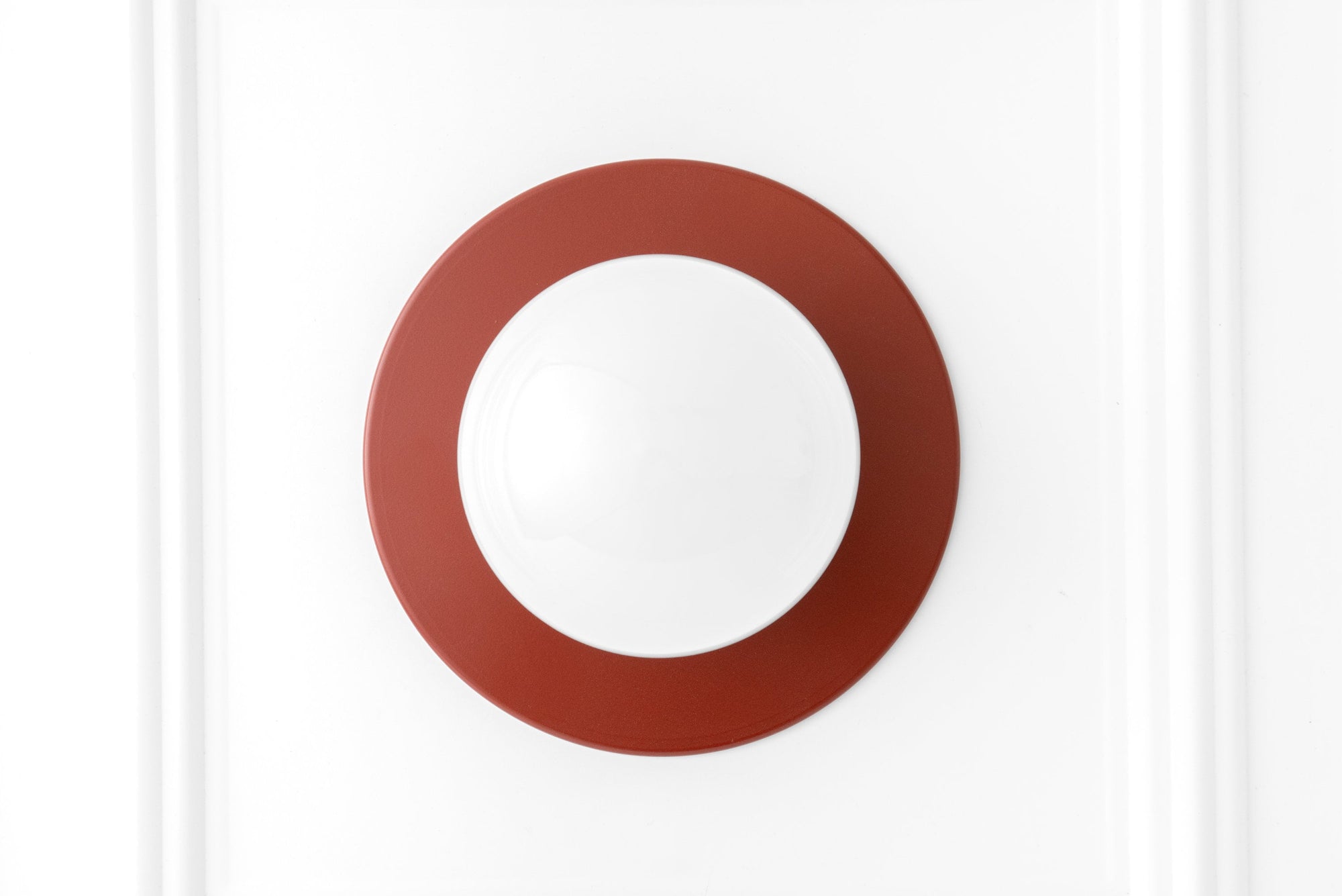 Scandinavian-style wall sconce with a round white globe and brick red circular base flush mounted on white wall. - SCONCE MODEL NO. 2277