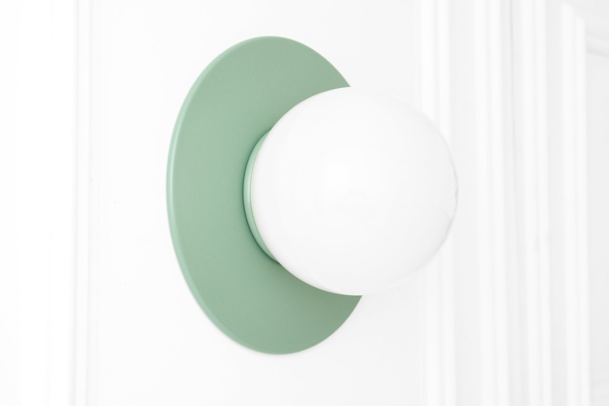 Scandinavian-style wall sconce with matte green circular base and white globe light. - SCONCE MODEL NO. 2277