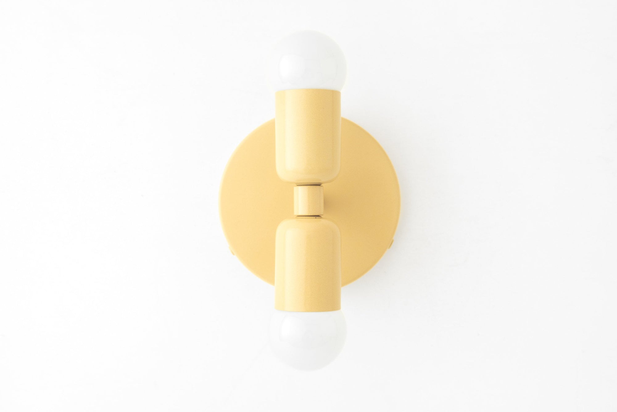 Mid-century modern yellow sconce with up and down exposed bulbs and round backplate. - SCONCE MODEL NO. 2660