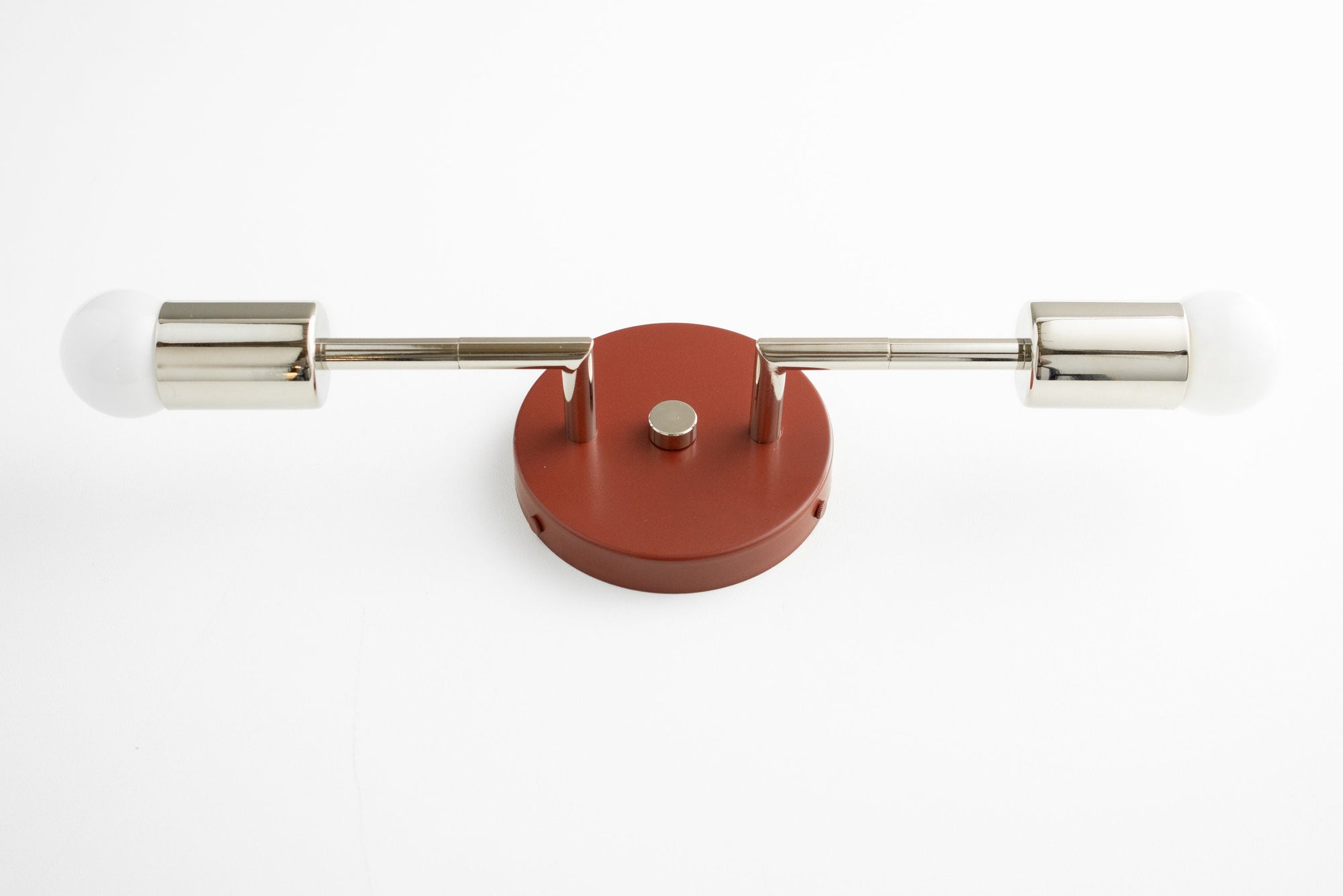 Mid-century modern vanity light with two bare bulbs, brushed nickel arms, and brick red base. - VANITY LIGHT MODEL NO. 1938