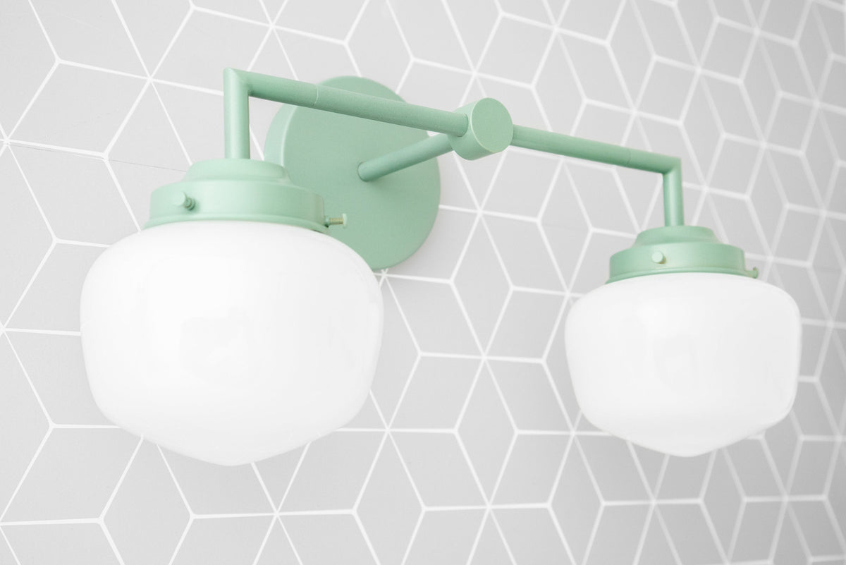 Art Deco two-bulb vanity light in soft green with frosted white globe shades and geometric wall mount. - VANITY LIGHT MODEL NO. 0276