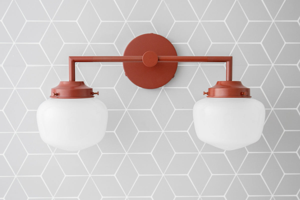 Art Deco style 2-bulb vanity light in brick red with white globe shades mounted on geometric gray wall. - VANITY LIGHT MODEL NO. 0276