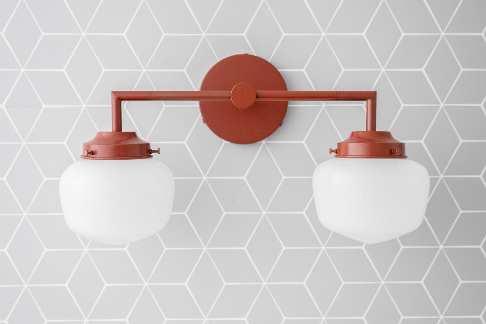 Art Deco style 2-bulb vanity light in brick red with round white glass globes mounted on geometric gray background. - VANITY LIGHT MODEL NO. 0276